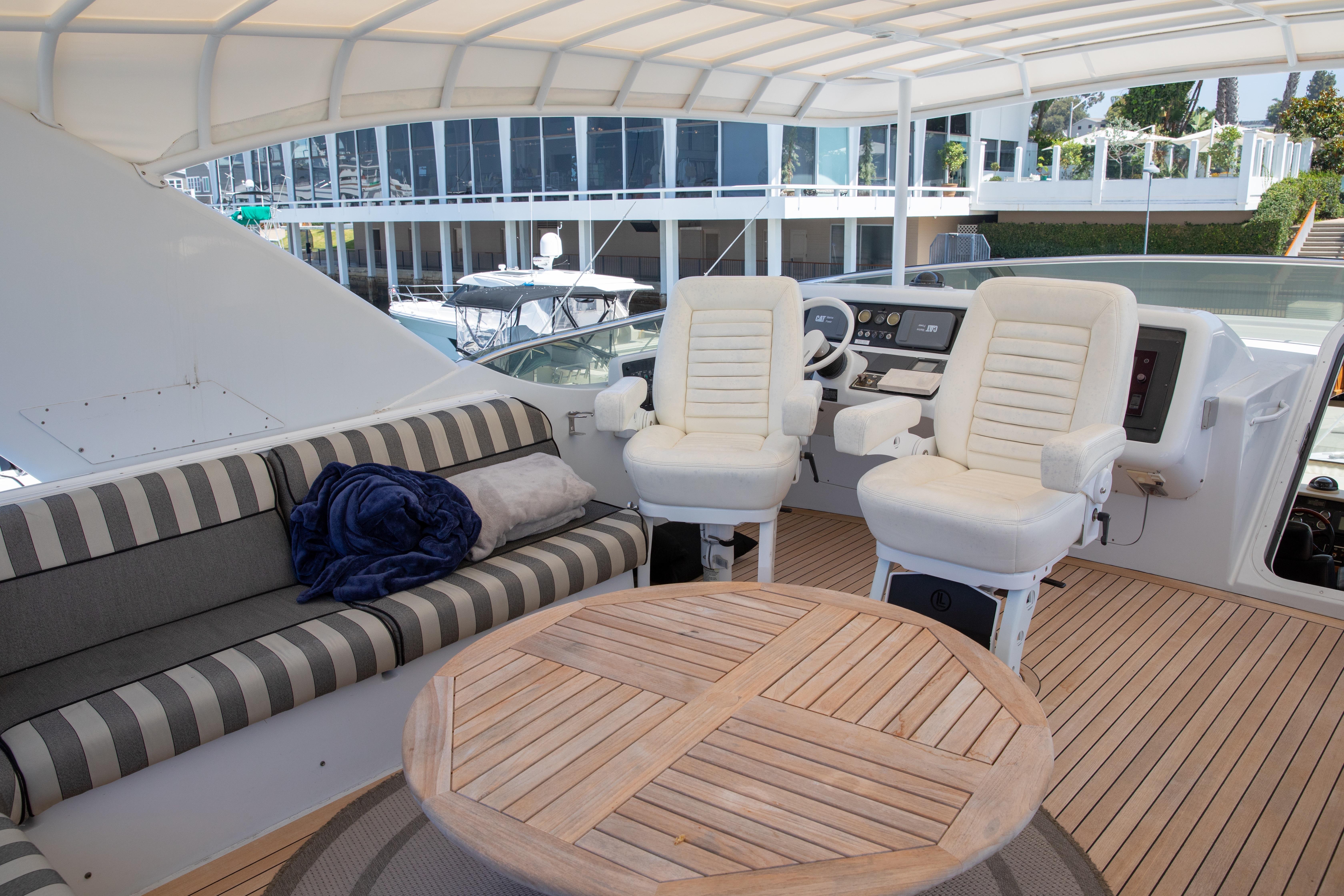 Luxurious 2002 Hatteras 63 Raised Pilothouse Motor Yacht interior with seating and helm.