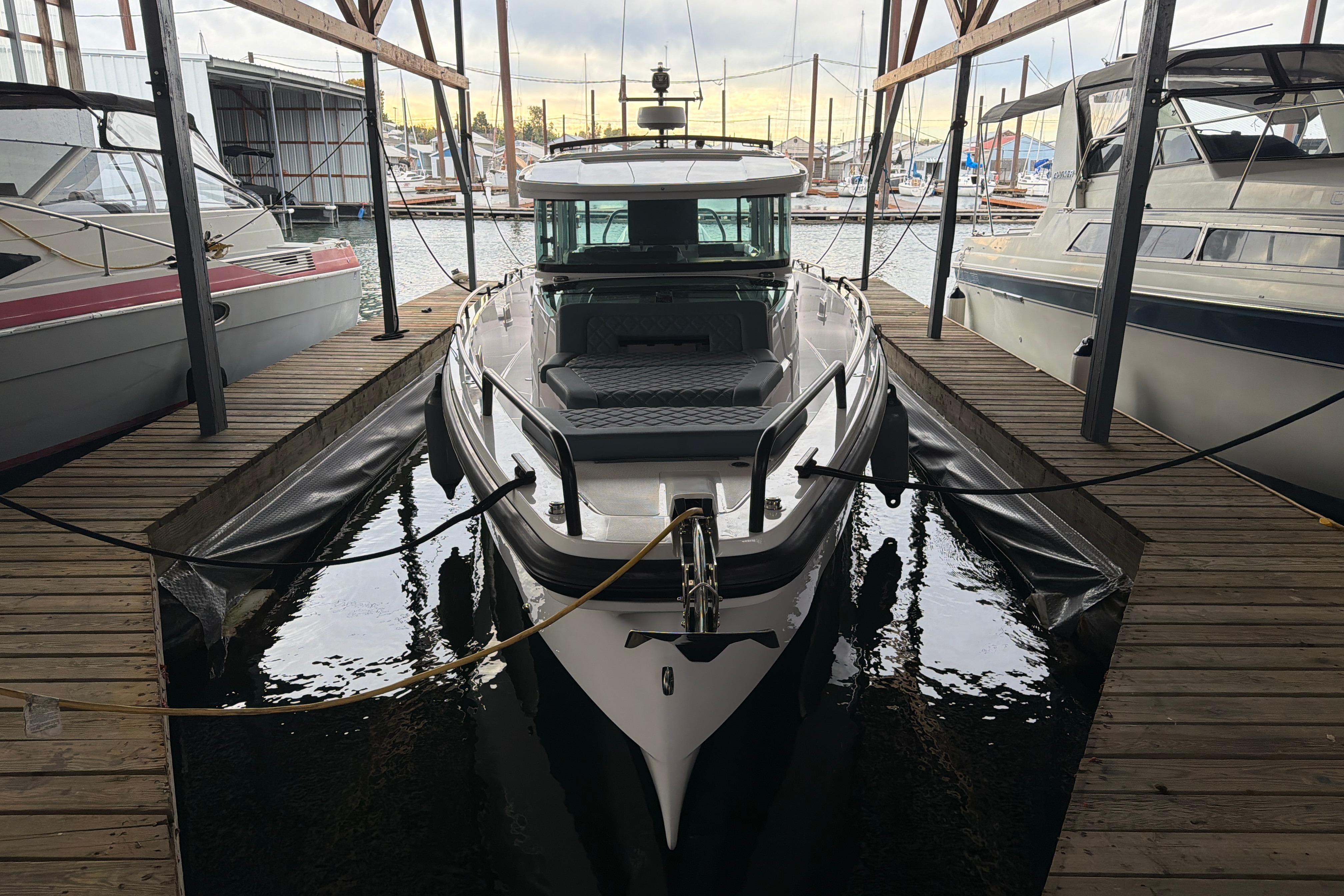 2022 Axopar Brabus 37 XC Cross Cabin docked in a marina, surrounded by other boats.