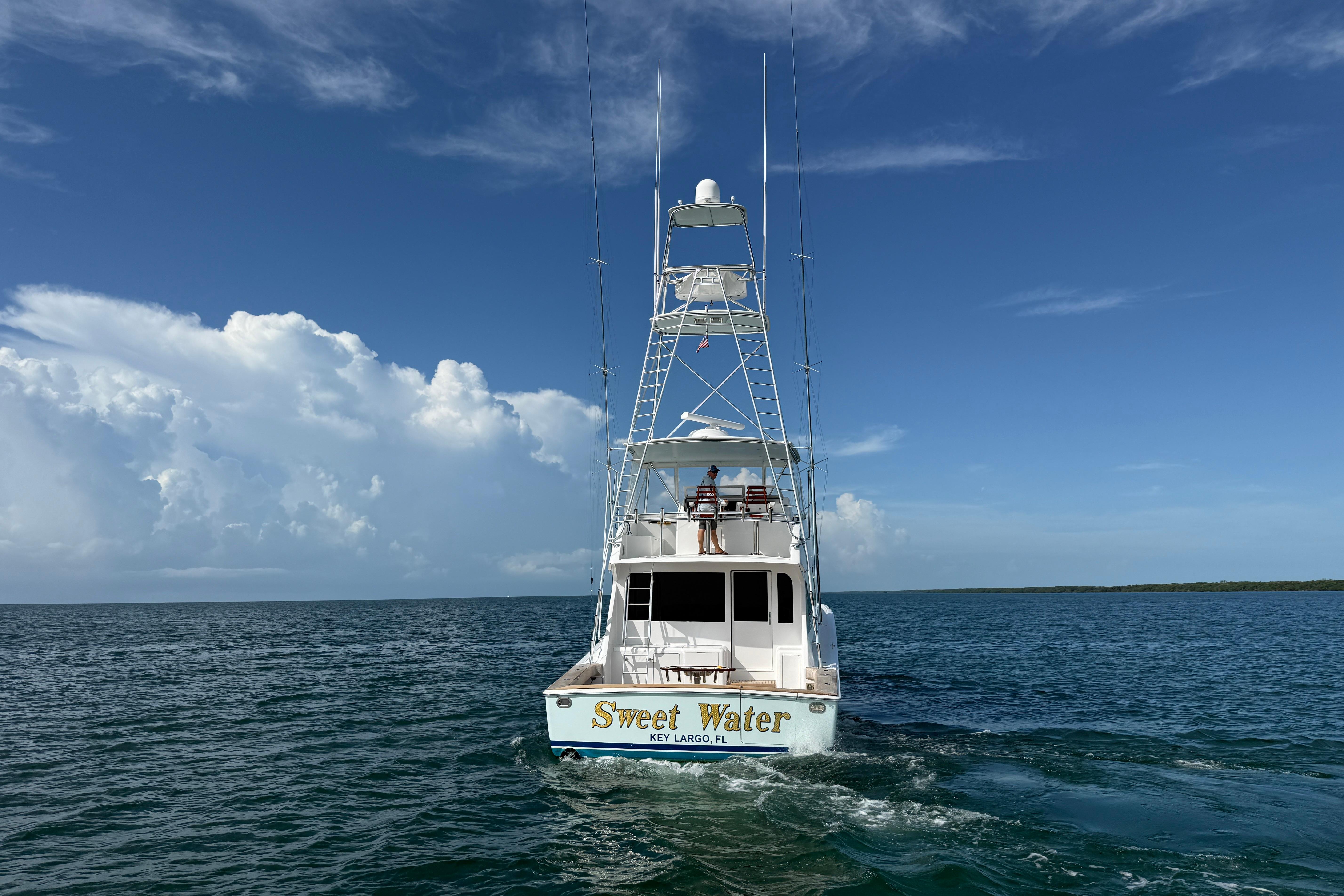 Viking 55 Convertible 2000 yacht "Sweet Water" cruising in open sea under clear skies.