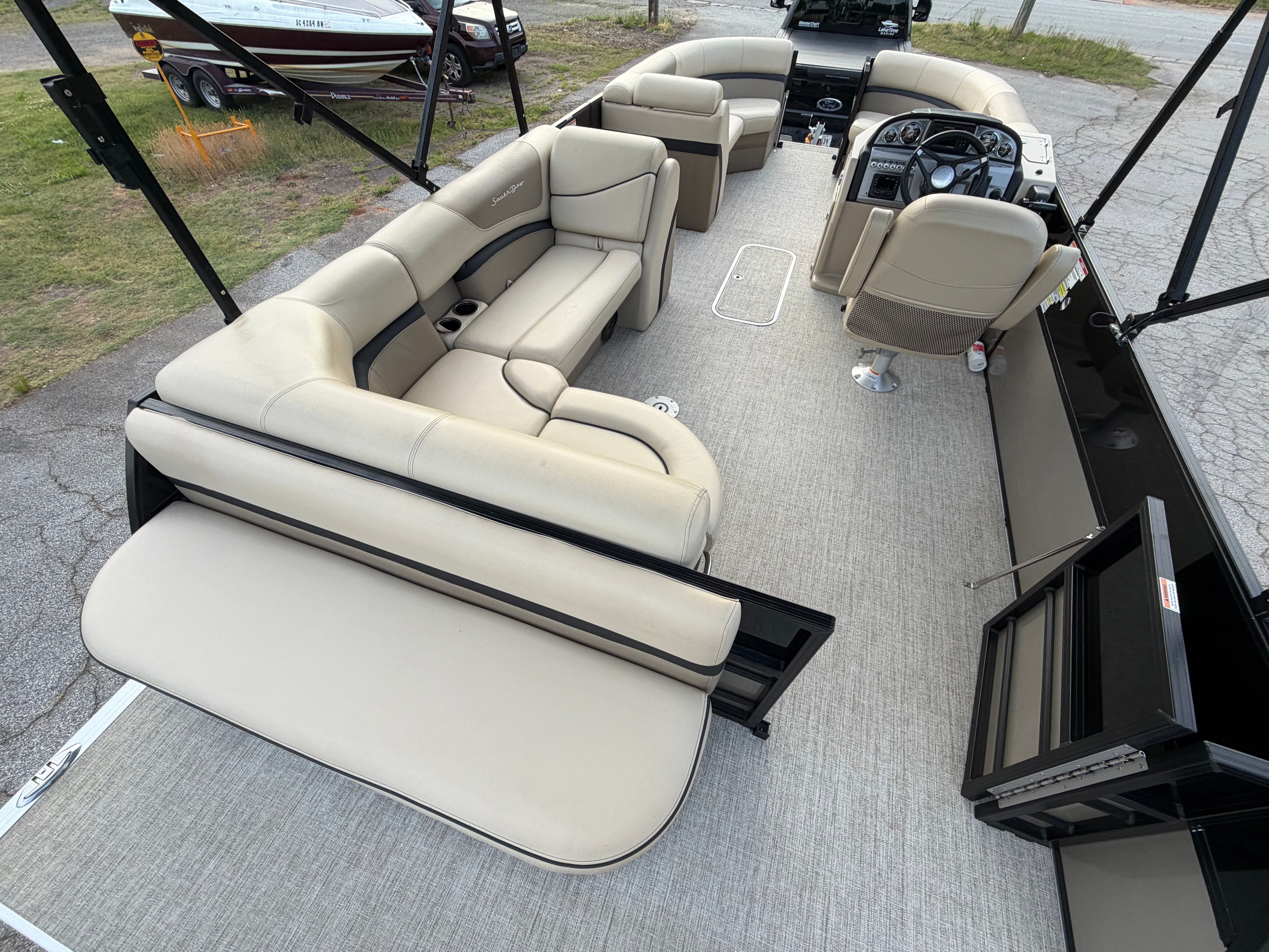 Interior of a 2023 South Bay S222 CR2 pontoon boat with beige seating.