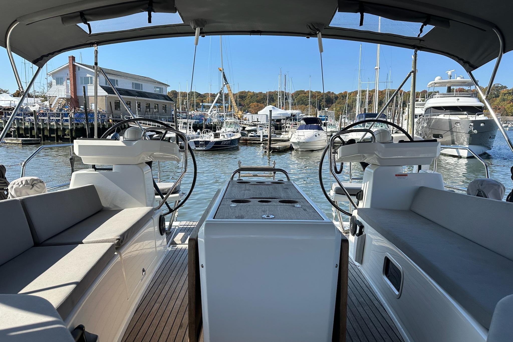 Cockpit view of 2018 Jeanneau 51 yacht docked at a marina with other boats.
