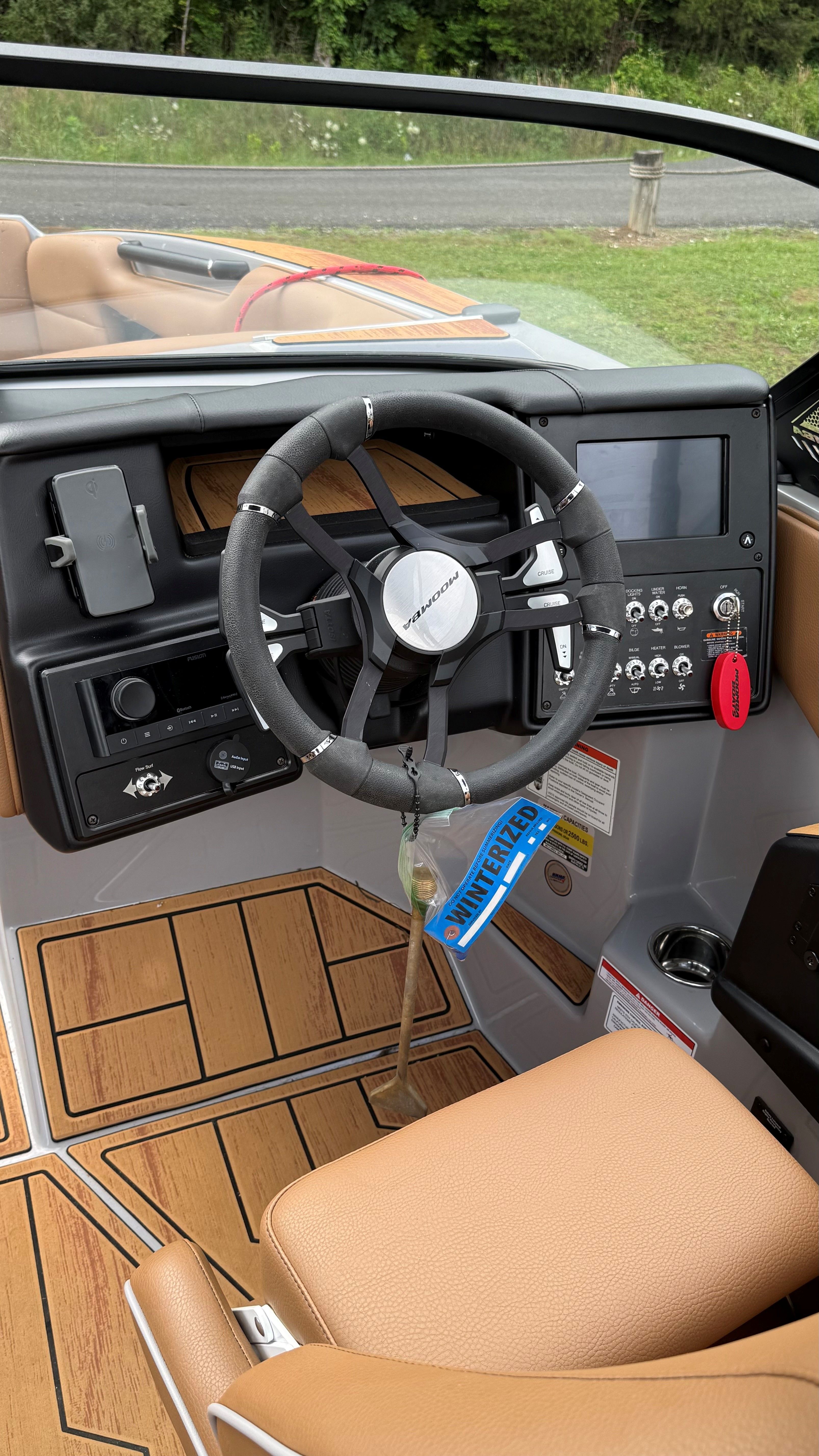 The image shows the cockpit of a 2025 Malibu Mojo boat with a modern steering wheel.