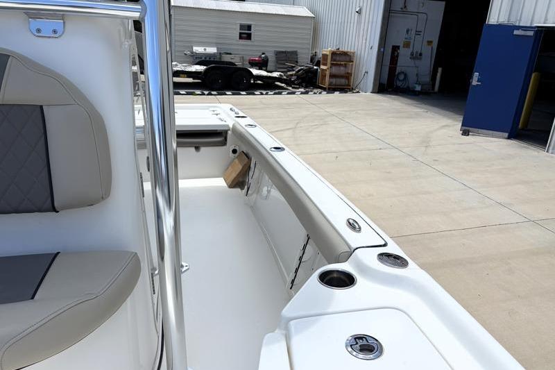 2025 Key West 210 Bay Reef boat interior with seating and storage, docked near industrial buildings.
