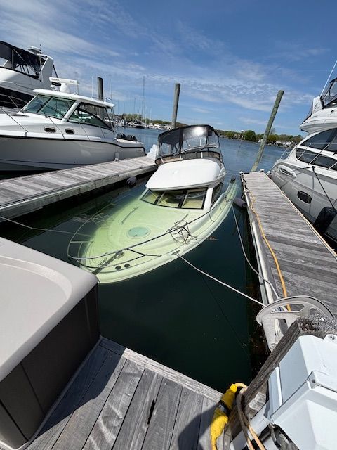 A 2004 Meridian 341 Sedan is docked, surrounded by other boats.