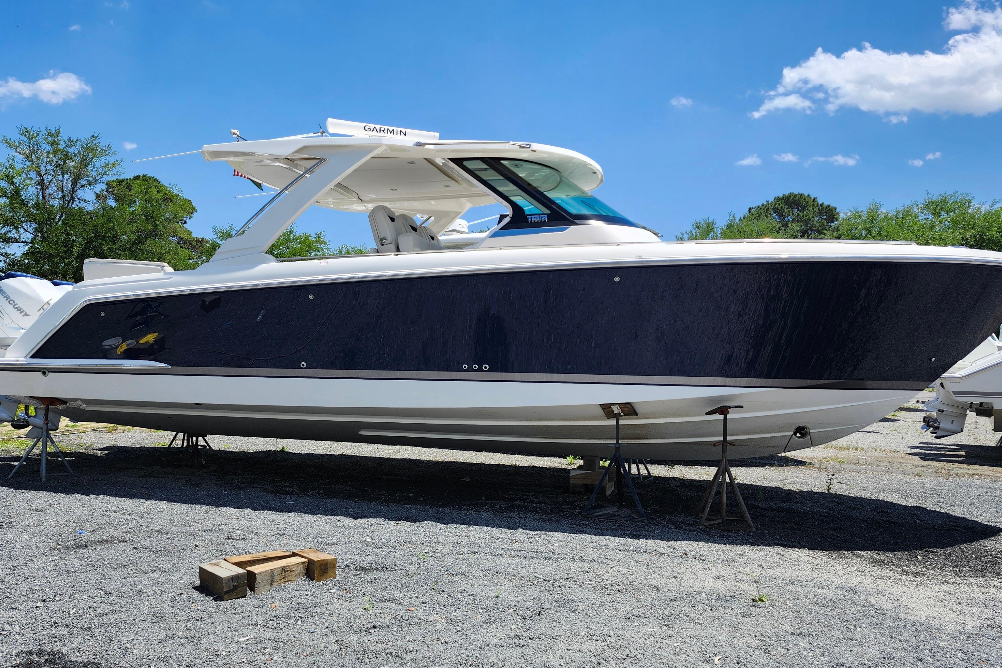 2022 Tiara Yachts 38 LS boat on stands, clear sky background.