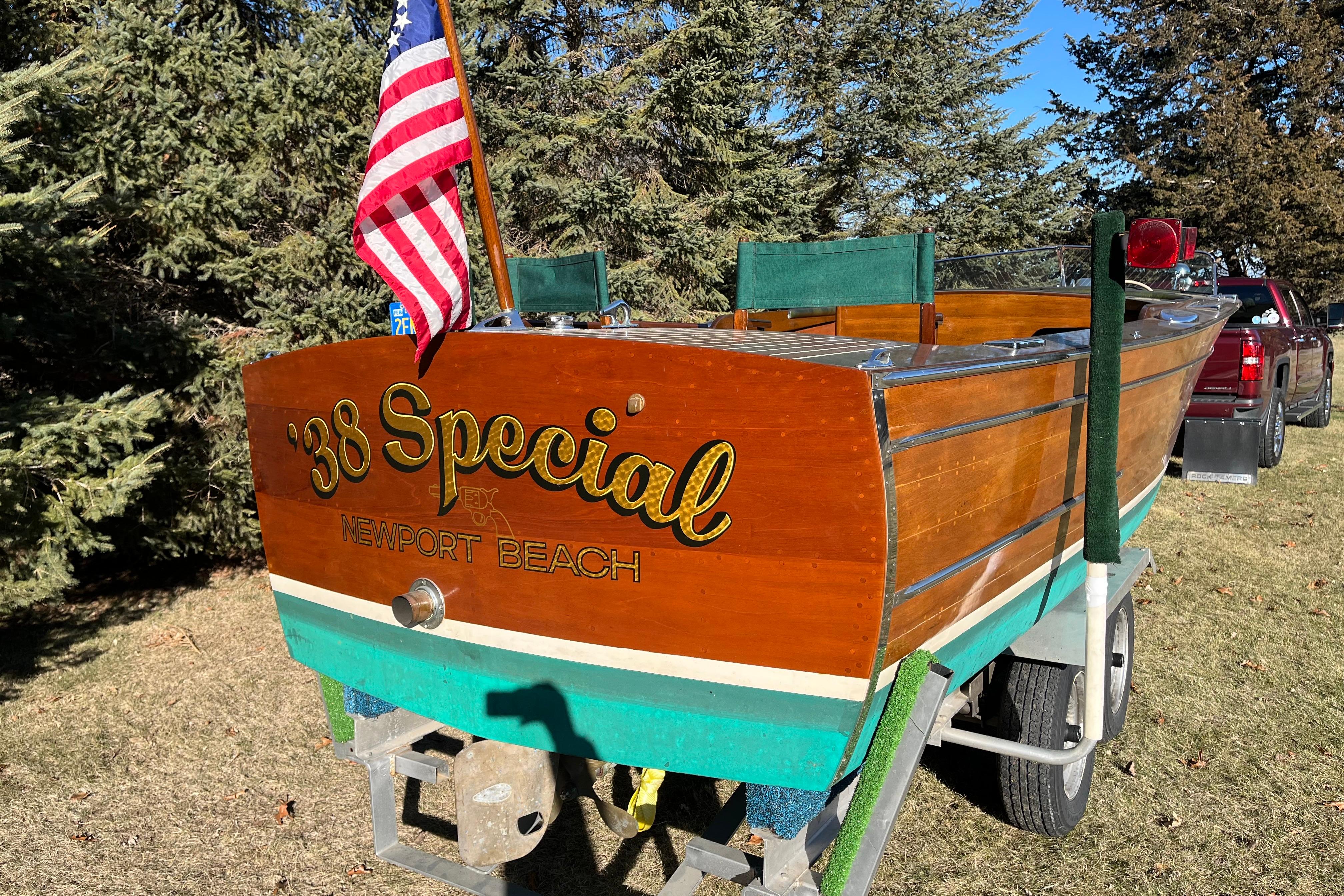 Vintage 1938 Chris-Craft 28 Sportsman boat with American flag, Newport Beach lettering.