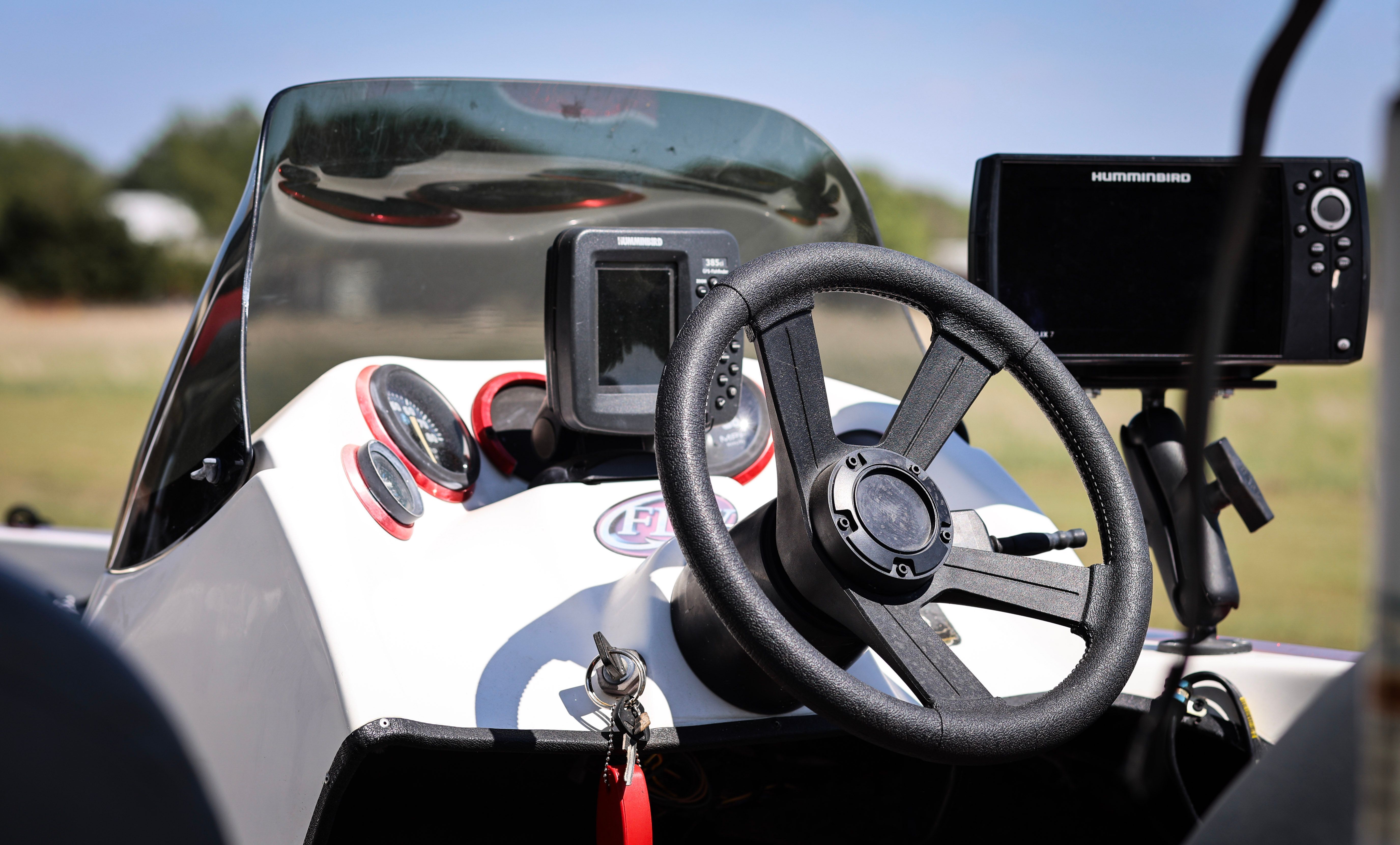 The image shows the cockpit of a 1999 Champion Bass boat with steering wheel and electronics.