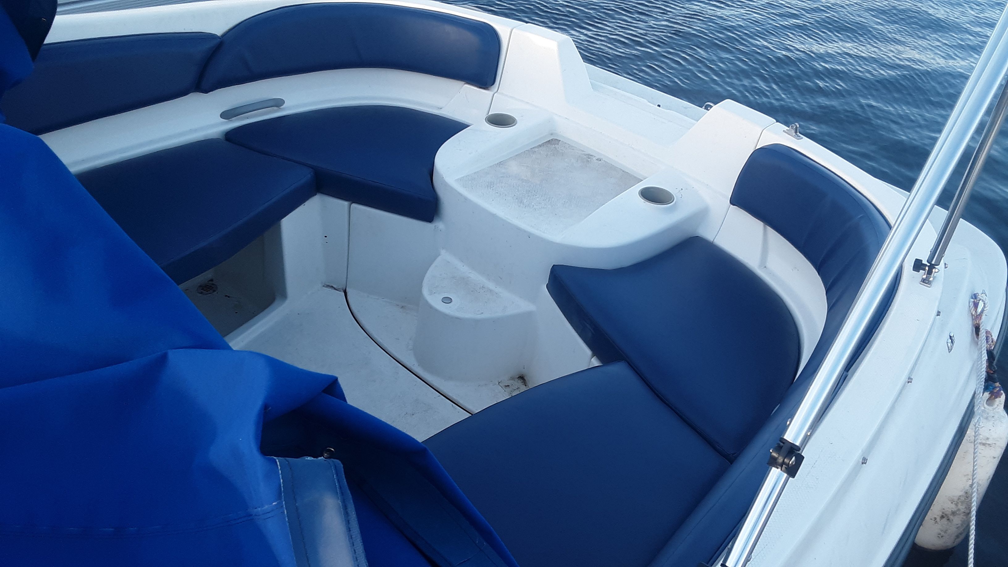The image shows the bow area of a Bayliner 210 Classic with blue cushions.