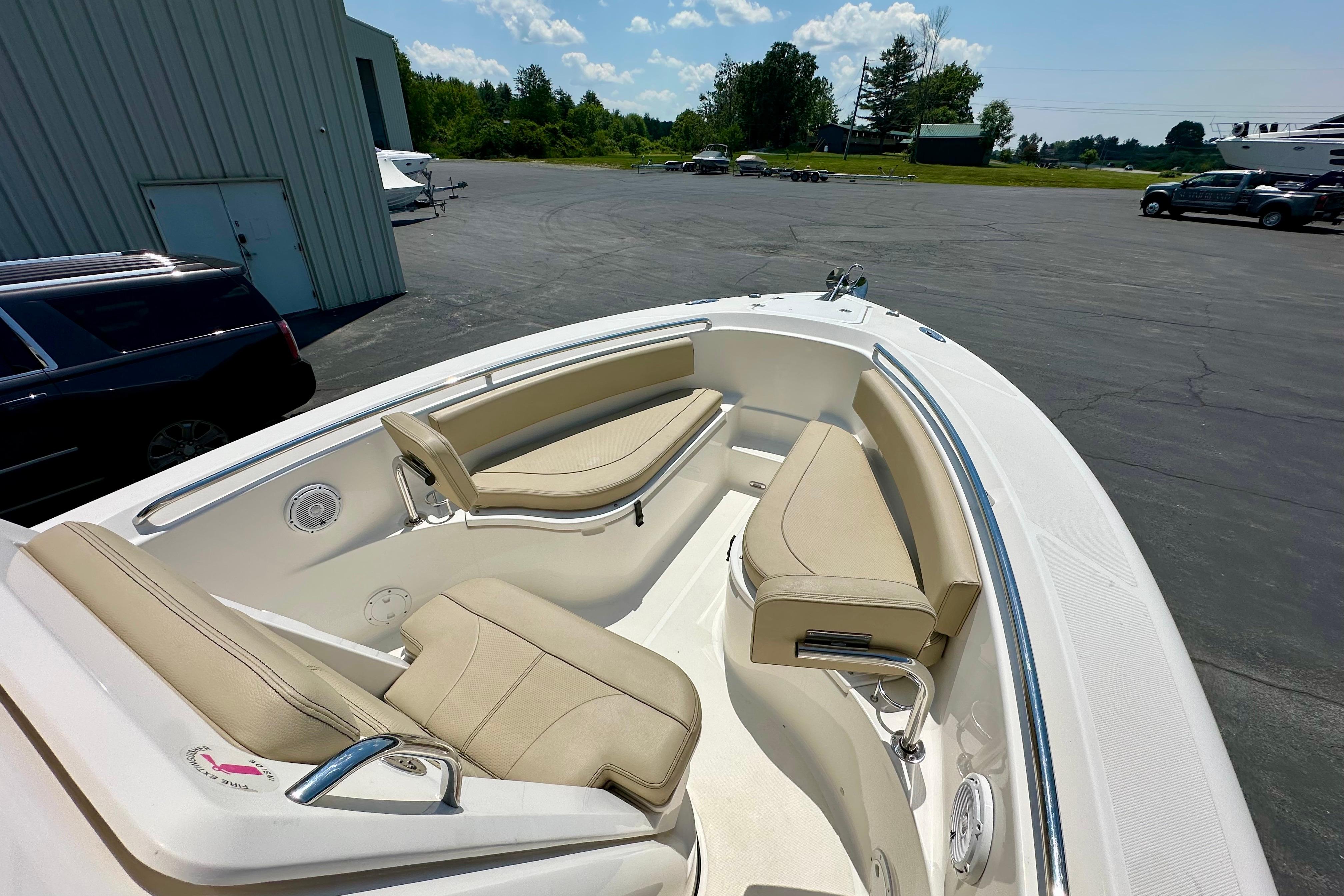 2020 Pursuit C 238 Center Console boat with beige seating, parked outdoors.