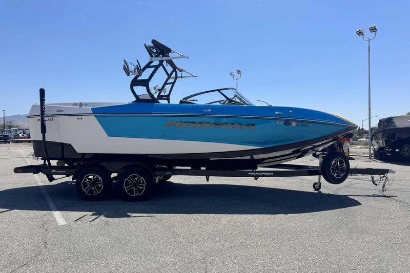 2023 Moomba Mojo Pro boat on trailer in parking lot, side view.