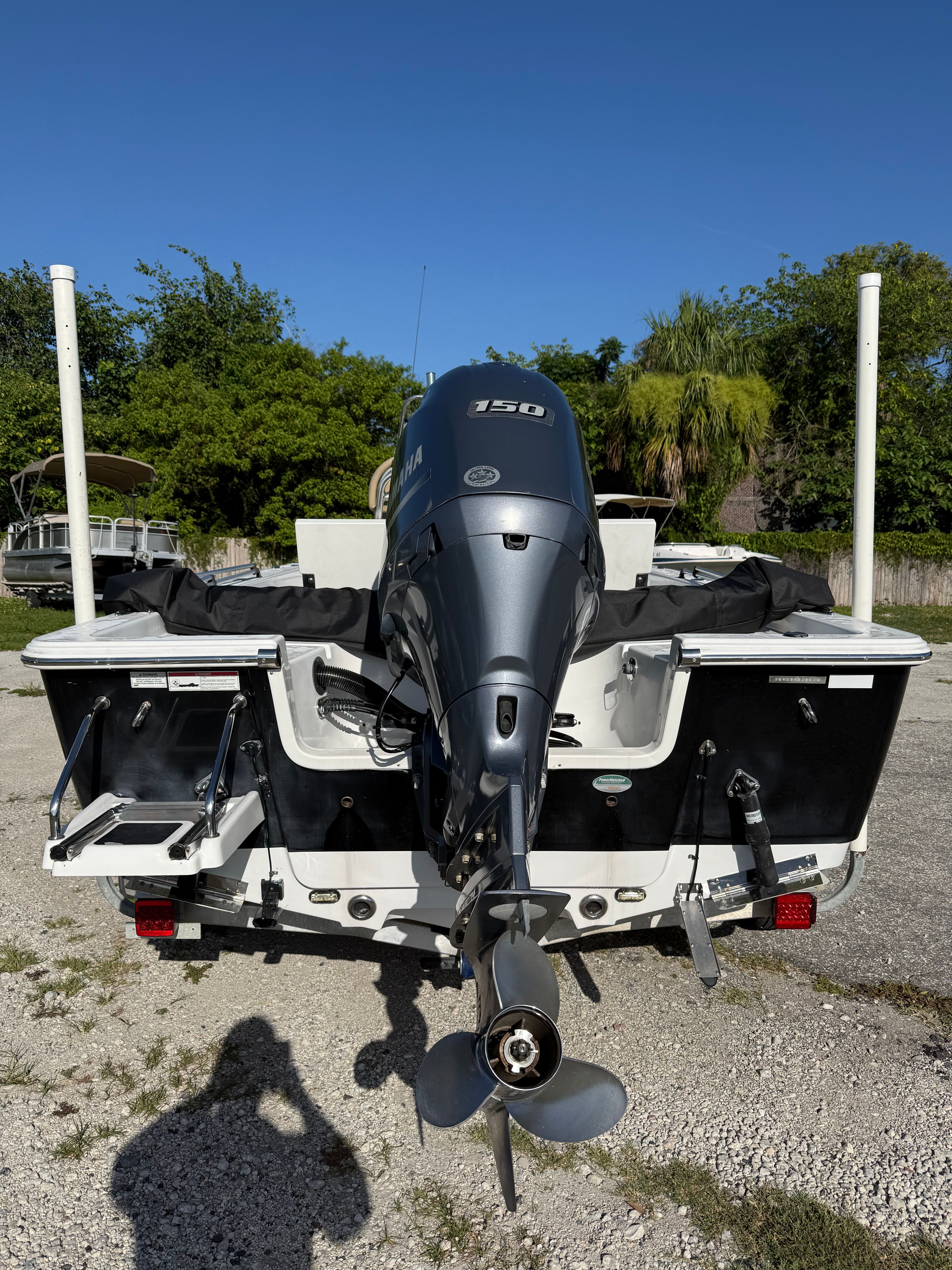 Rear view of a Sportsman Masters 227 Bay Boat with a 150 HP outboard motor.