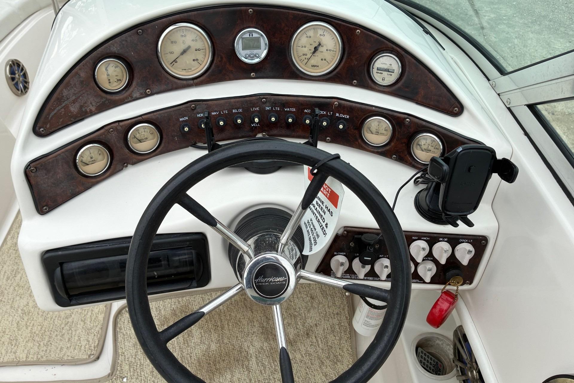 Steering console of a 2003 Hurricane 234 SD boat with gauges and controls.