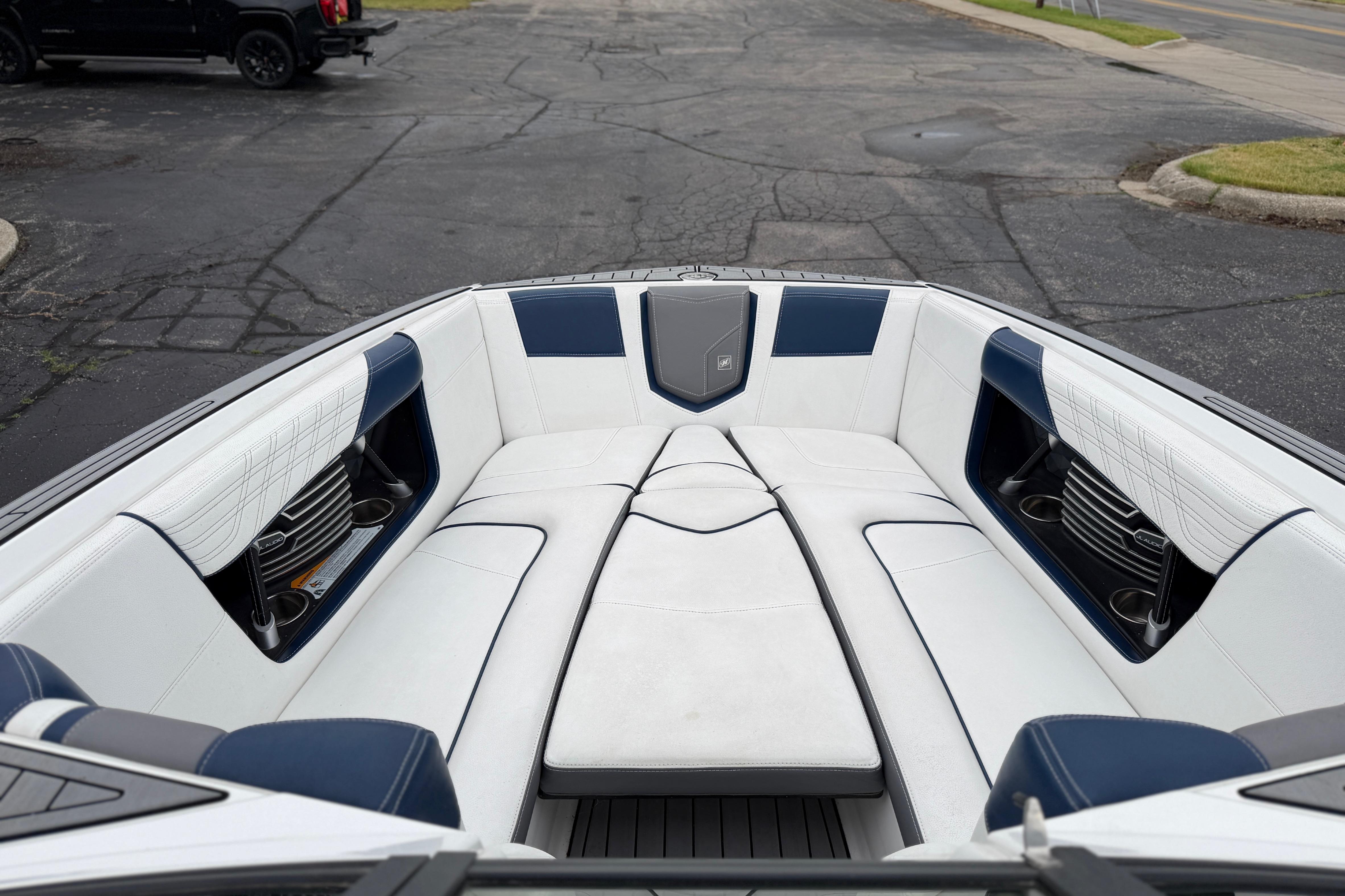 2016 Naitique G25 boat interior with white and blue seating, cup holders, and storage compartments.