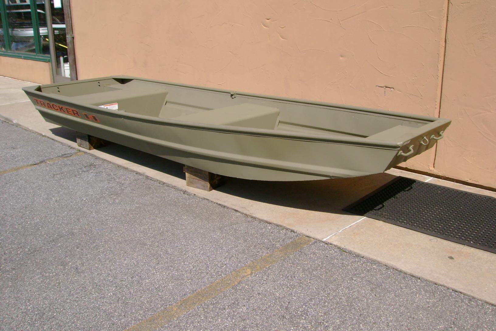 2026 Tracker Grizzly 14 Jon boat displayed outdoors on wooden blocks.