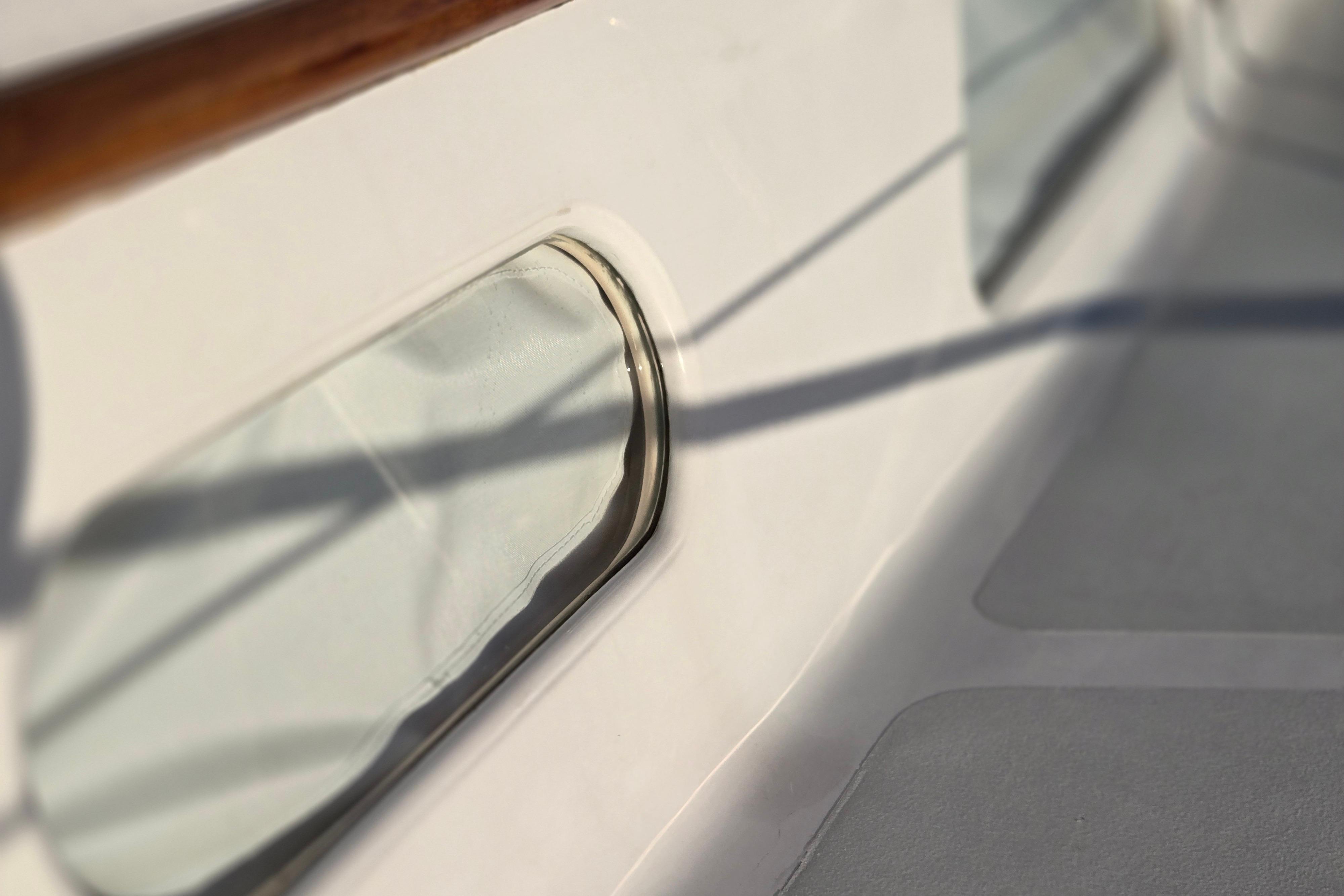 Close-up of a 1970 Hinckley Bermuda 40 yacht window with wooden trim.