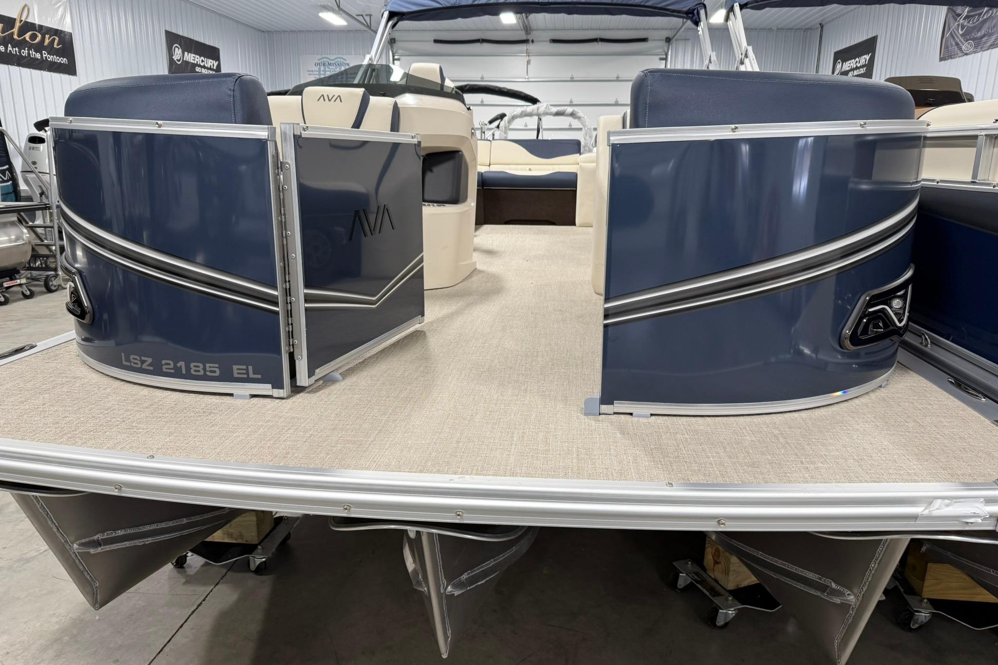 2026 Avalon LSZ Elite 21' pontoon boat, blue exterior, spacious deck, indoor showroom.