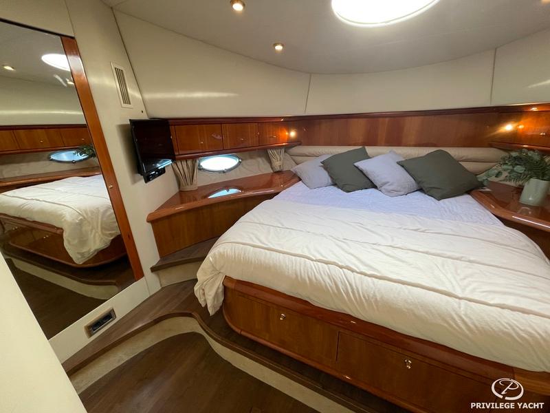 Luxurious bedroom interior of 2001 Sunseeker Manhattan 74 yacht with elegant wood finishes.
