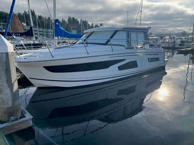 A 2021 Jeanneau NC 1095 is docked in a calm marina.