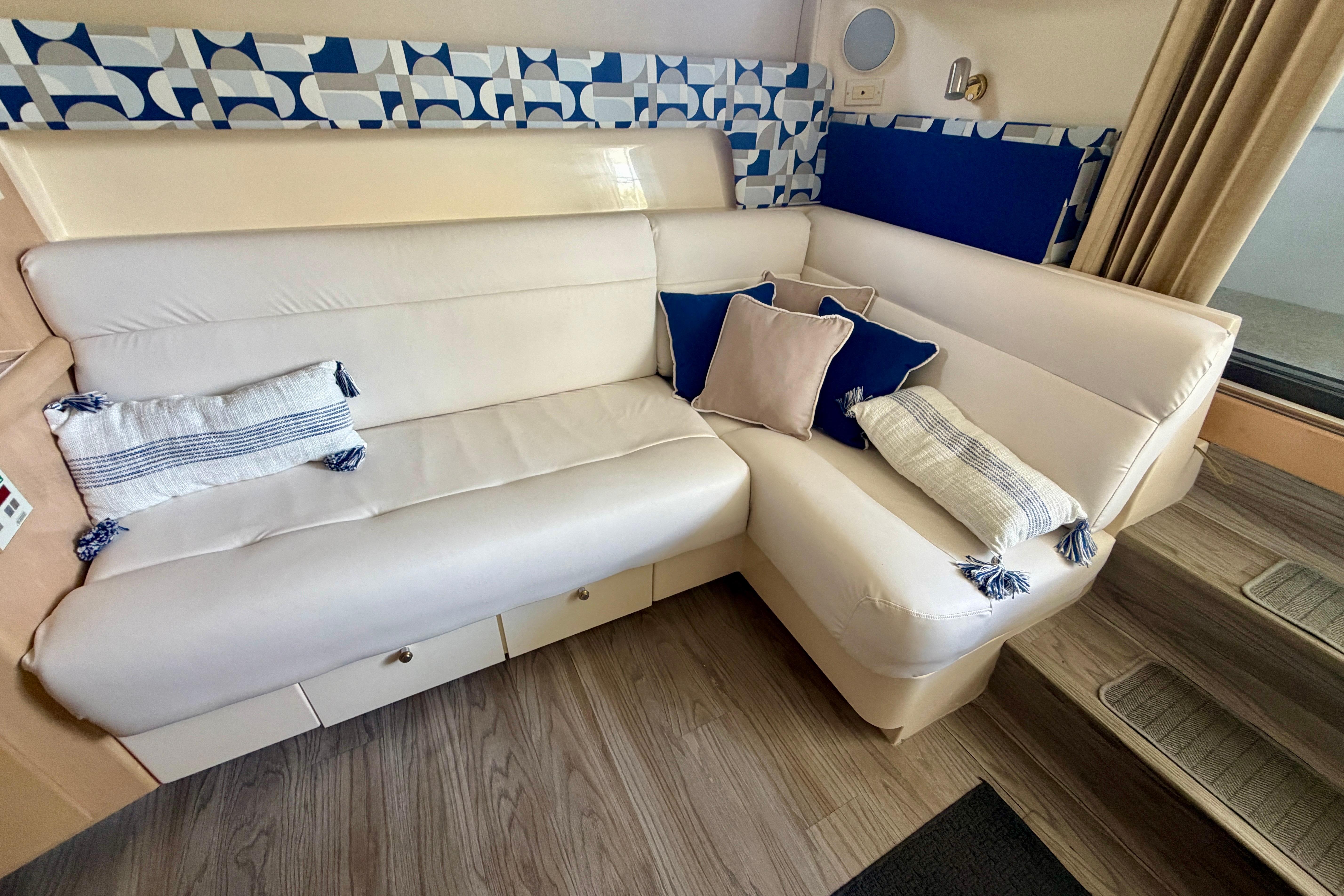 Luxurious interior of 2000 Carver 350 Mariner with plush white seating and decorative pillows.