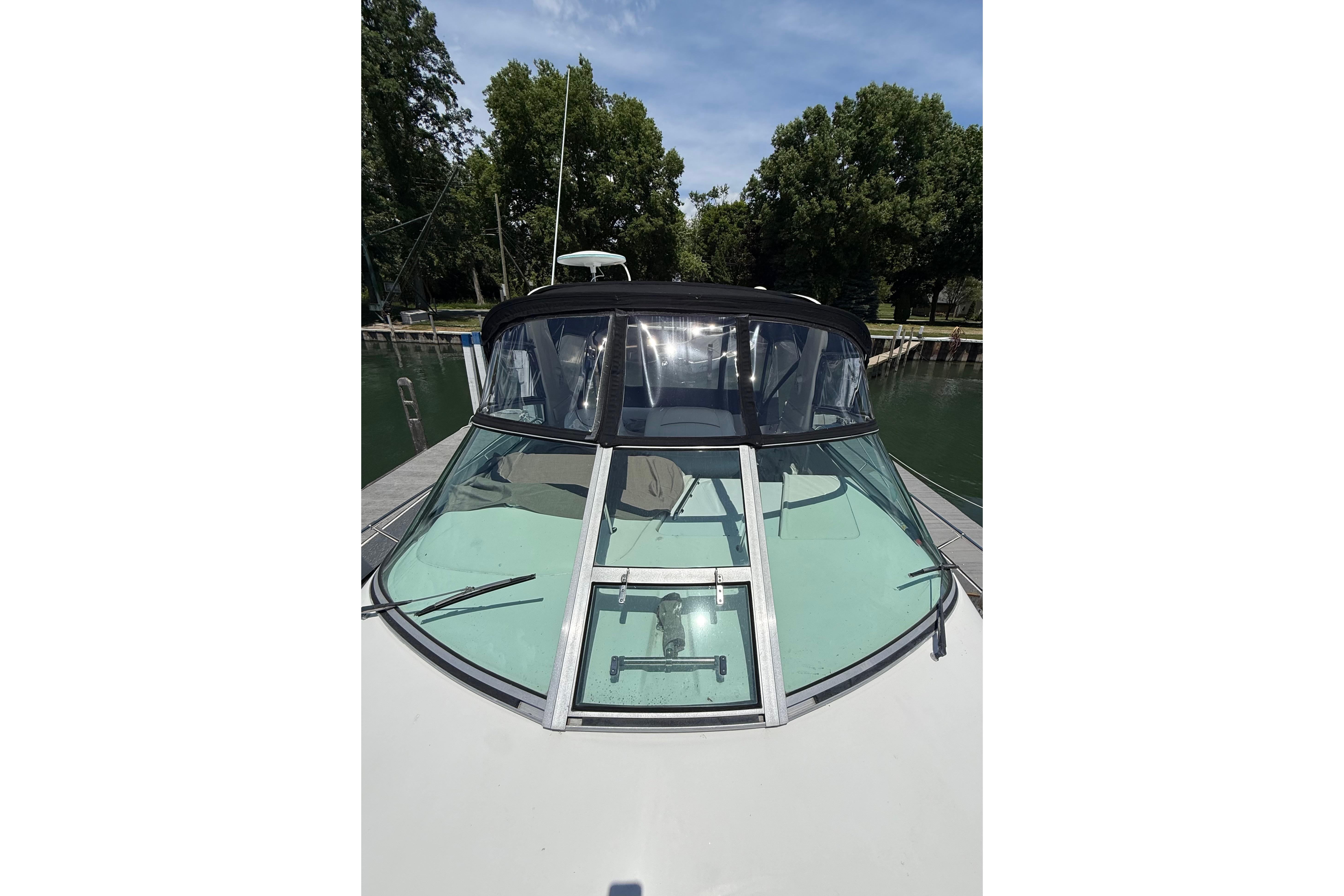 1999 Sea Ray Sundancer 310 boat docked, featuring a sleek windshield and canopy.