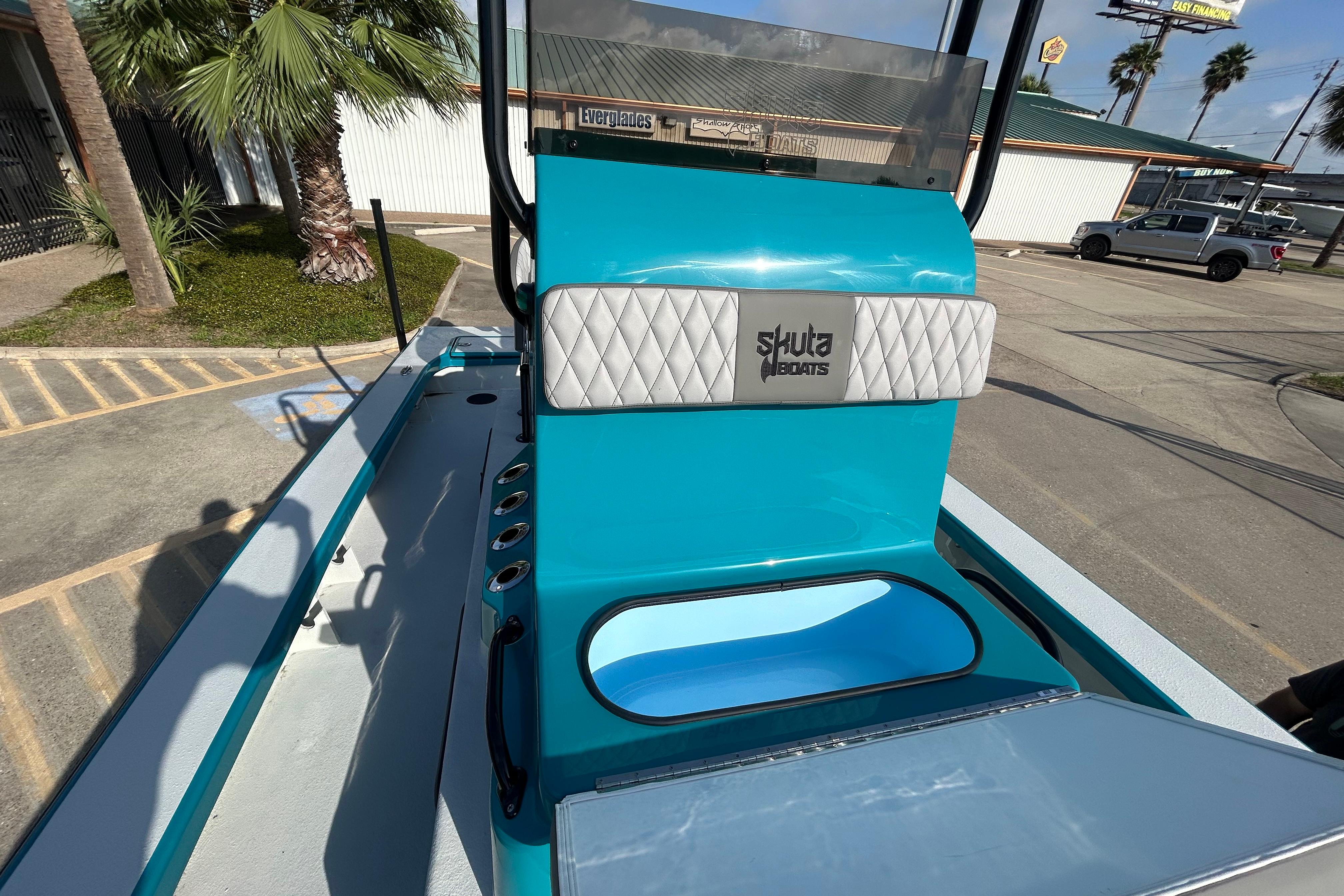 2026 Skuta 24 Skuta Cat boat with turquoise interior and Skuta Boats logo.