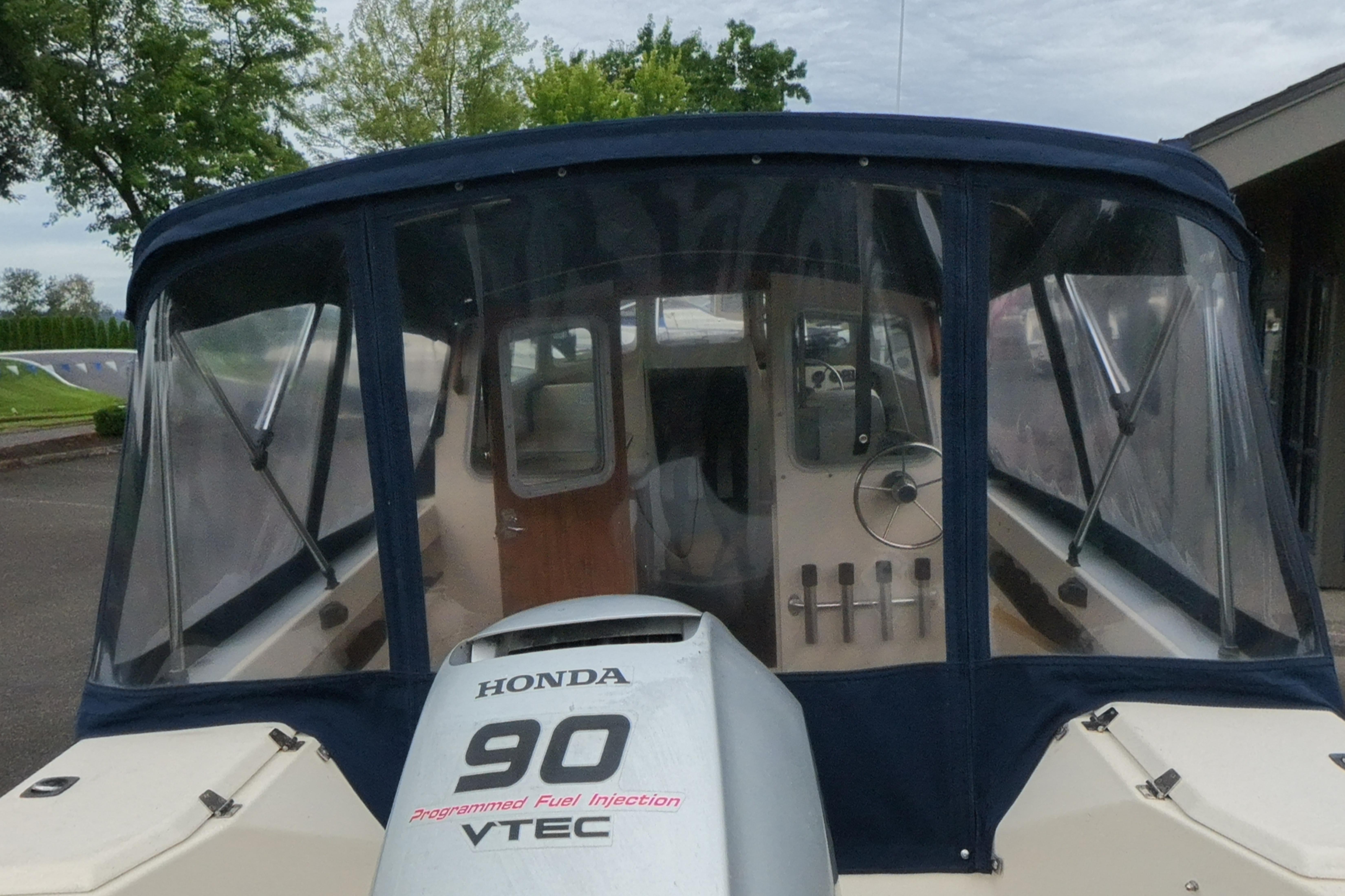1989 C-Dory 22' Angler boat with Honda 90 VTEC engine, docked outdoors.