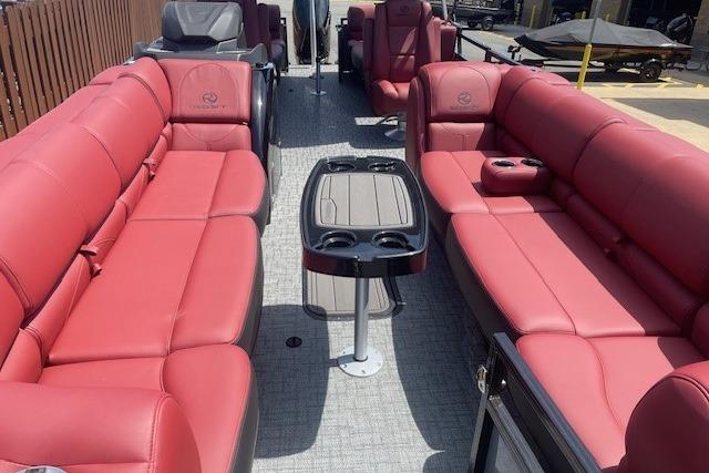Luxurious 2026 Regency 250 DL pontoon boat with red seating and central table.
