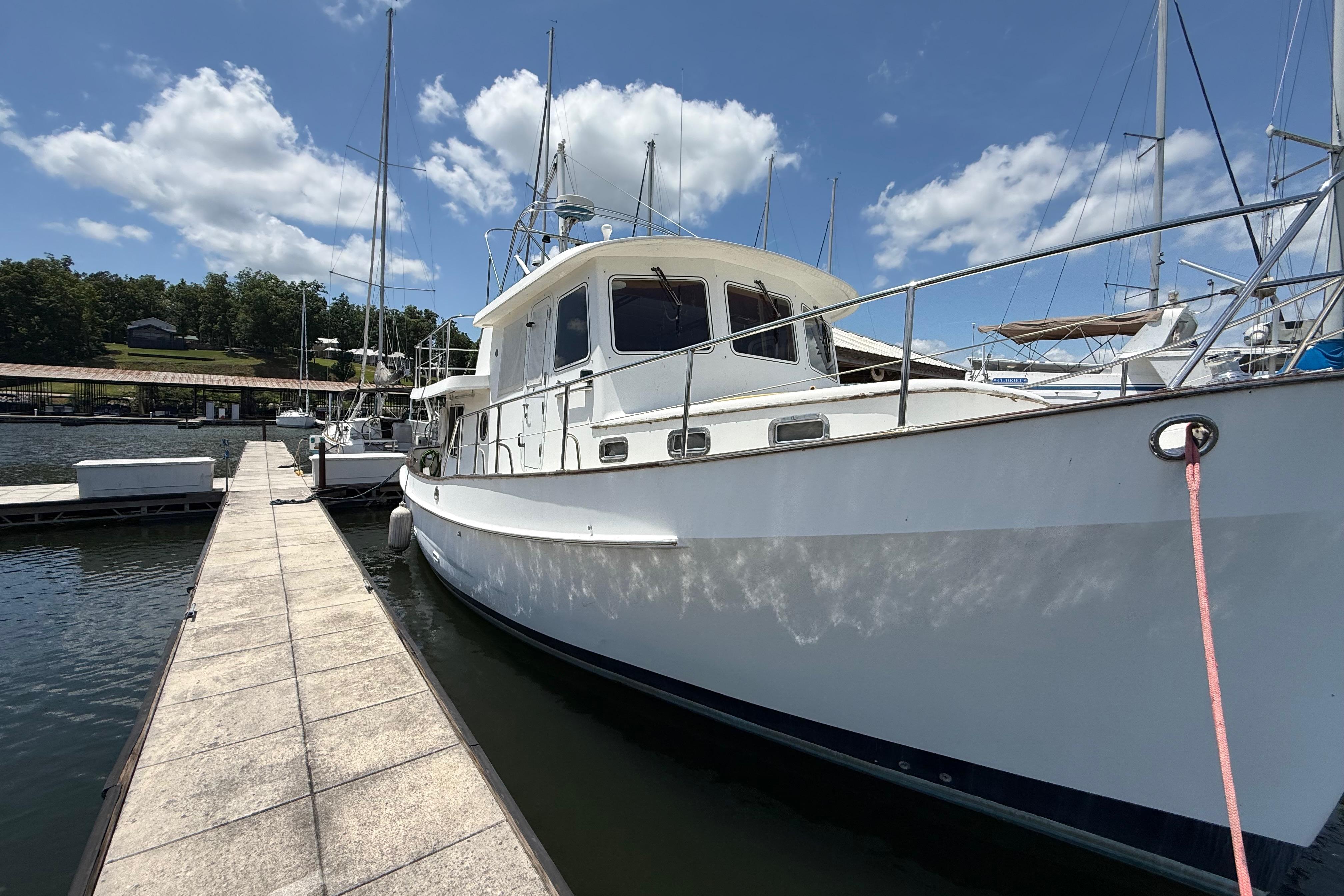 Kadey-Krogen 39 yacht from 2001 docked at a marina under a clear blue sky.