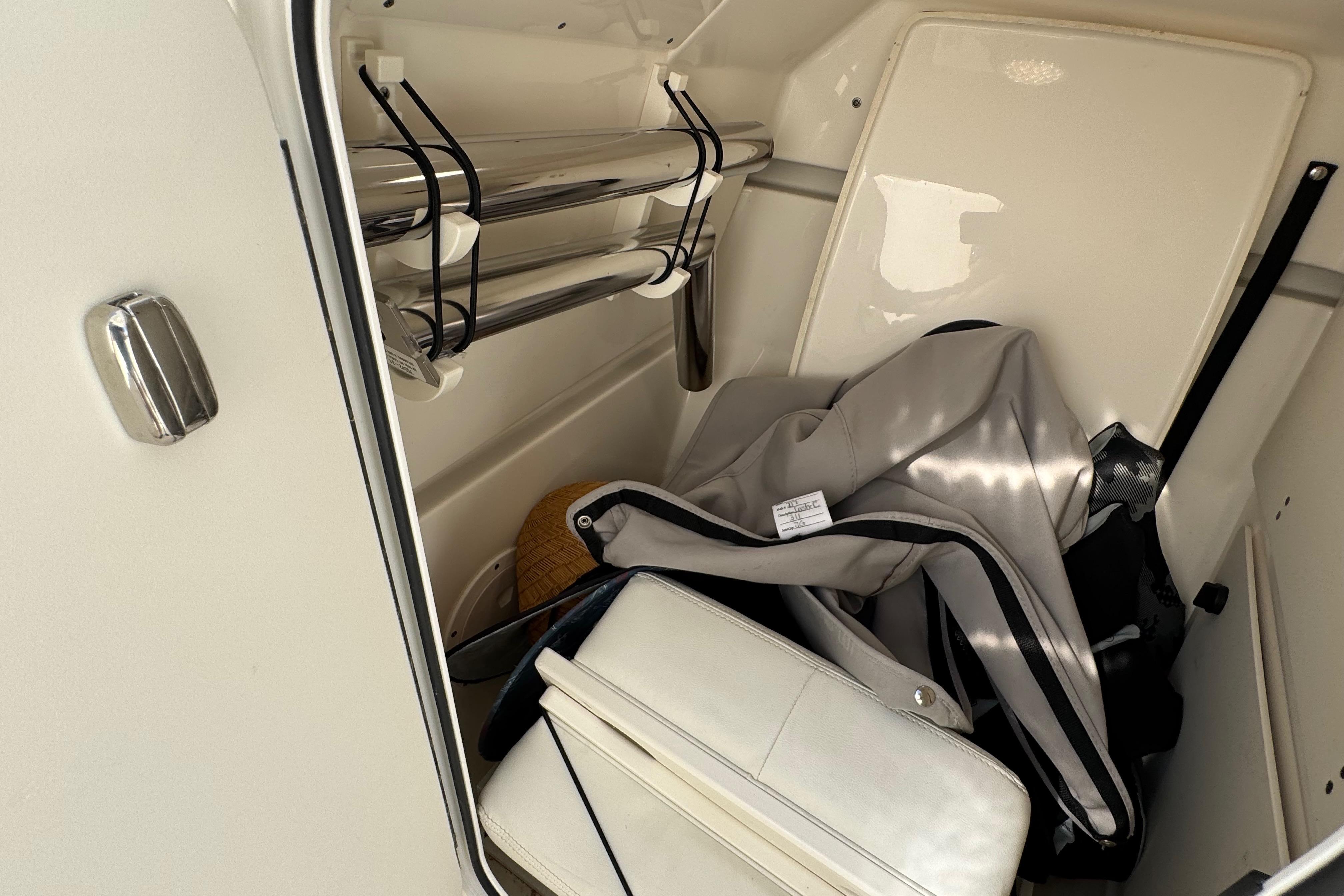 Storage compartment in 2022 Pursuit DC 266 Dual Console boat with gear and accessories.