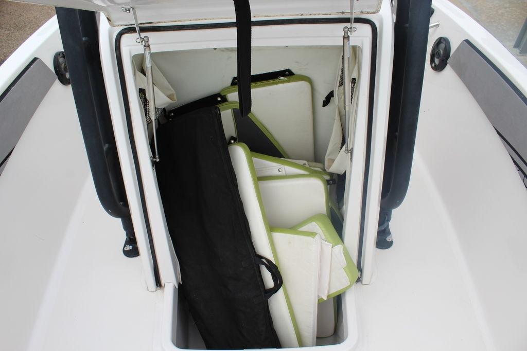 Open storage compartment on 2017 Scarab 195 boat with cushions and accessories.