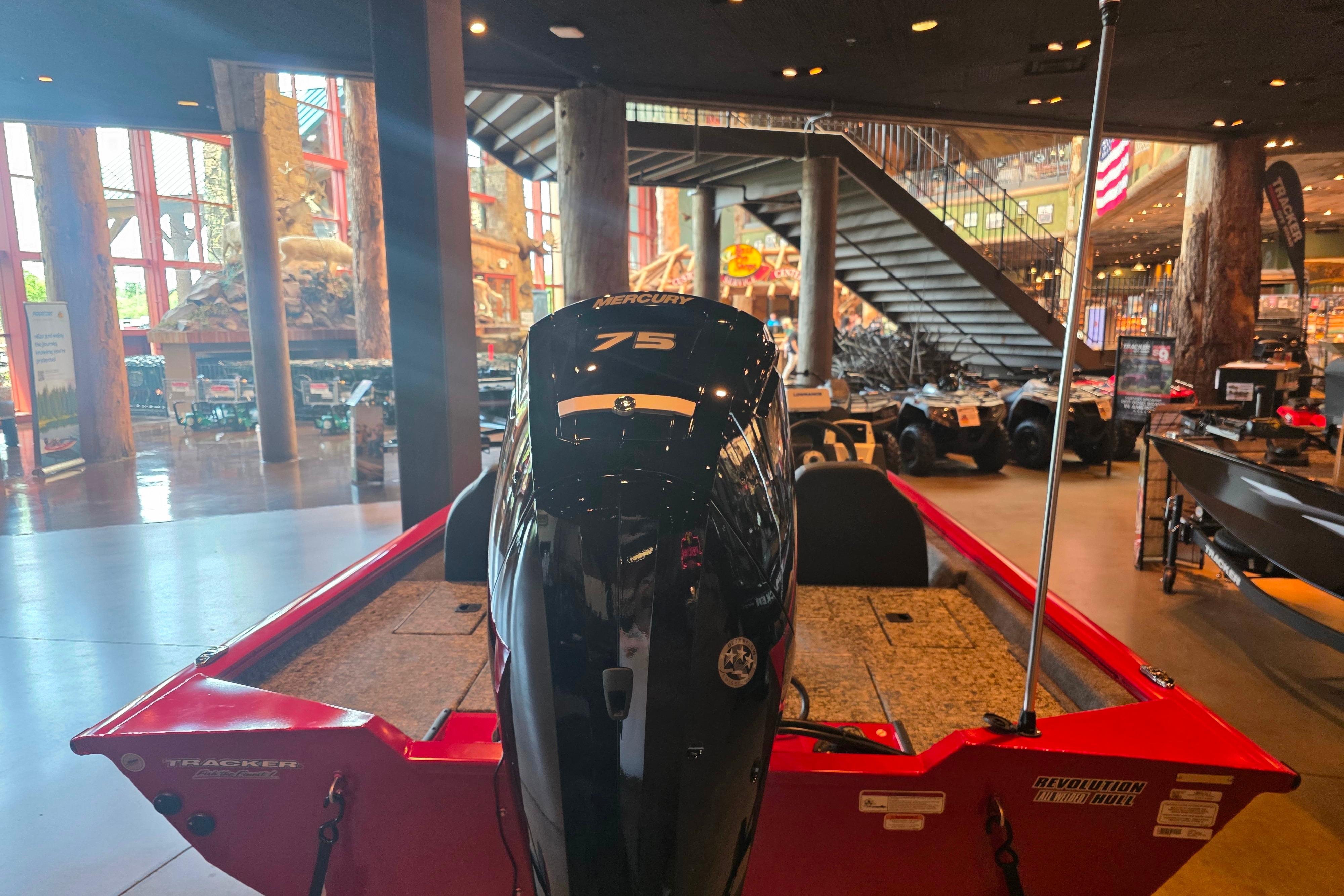 2026 Tracker Pro Team 175 boat with Mercury 75 engine displayed indoors.