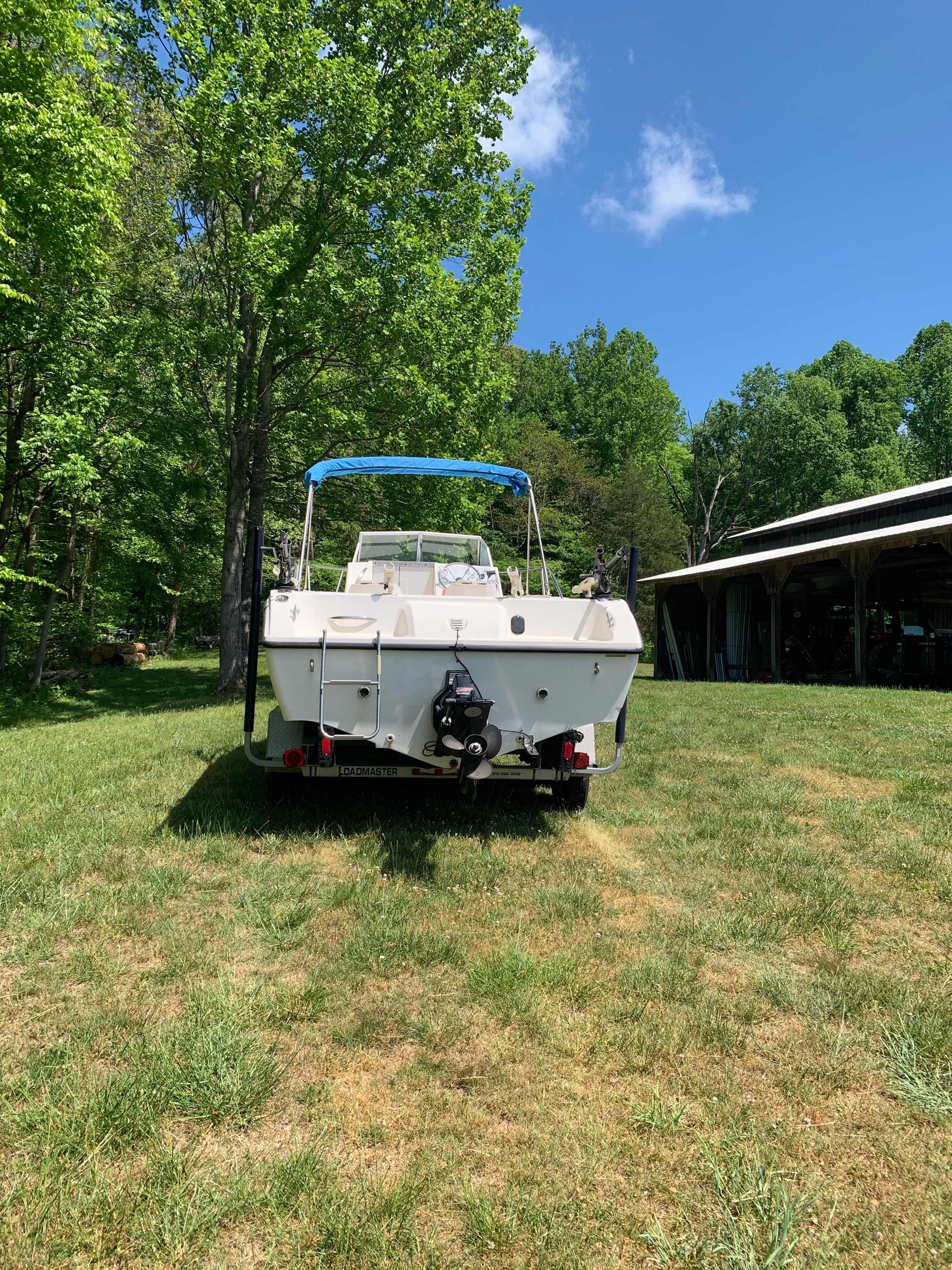 1998 Eurosport 221WA boat on grass with trees and shed.
