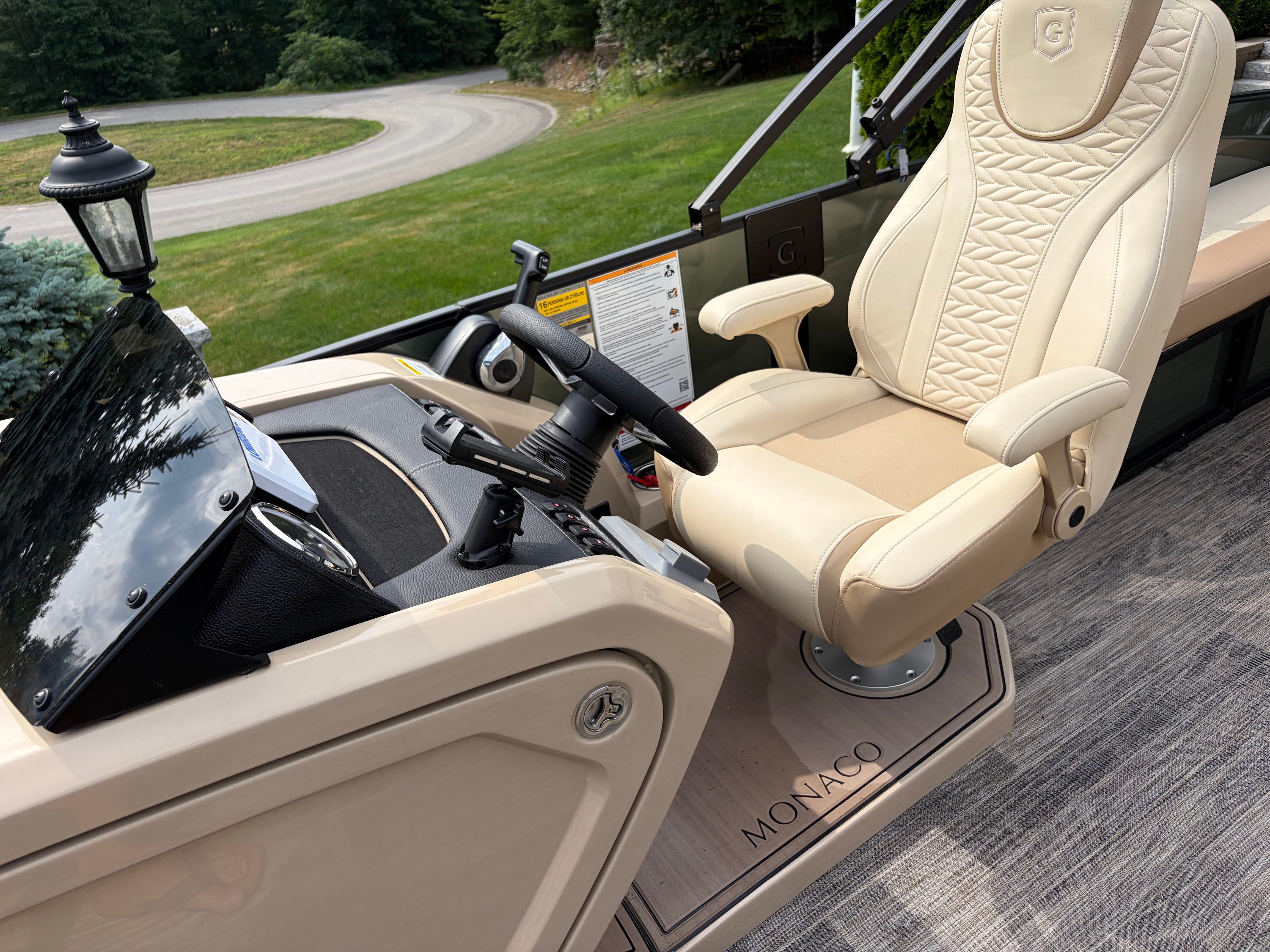 The image shows the helm of a 2025 Godfrey Monaco Cruise with a luxurious captain's chair.