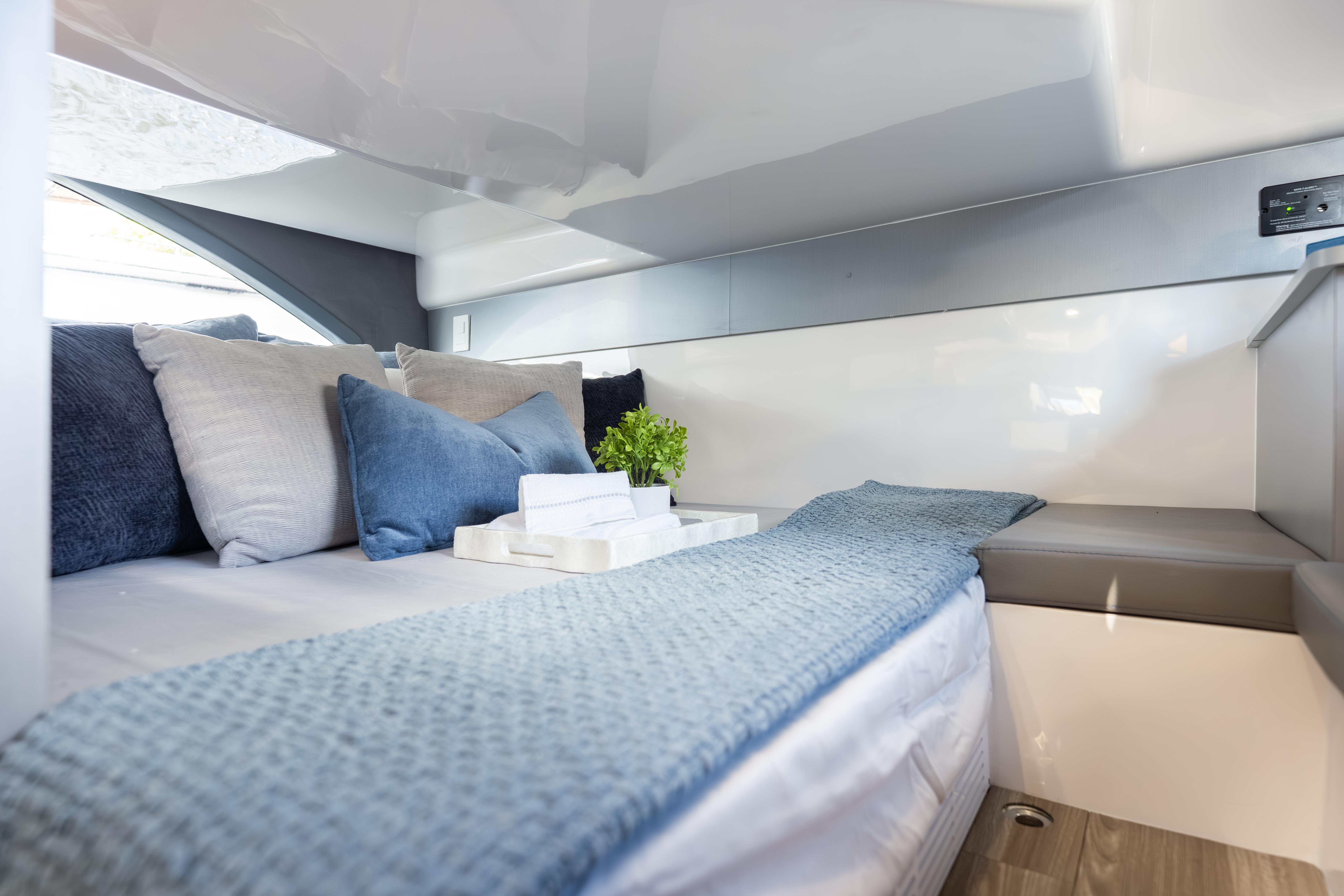 Luxurious interior of 2026 Hanover 347 yacht with cozy bedding and modern decor.