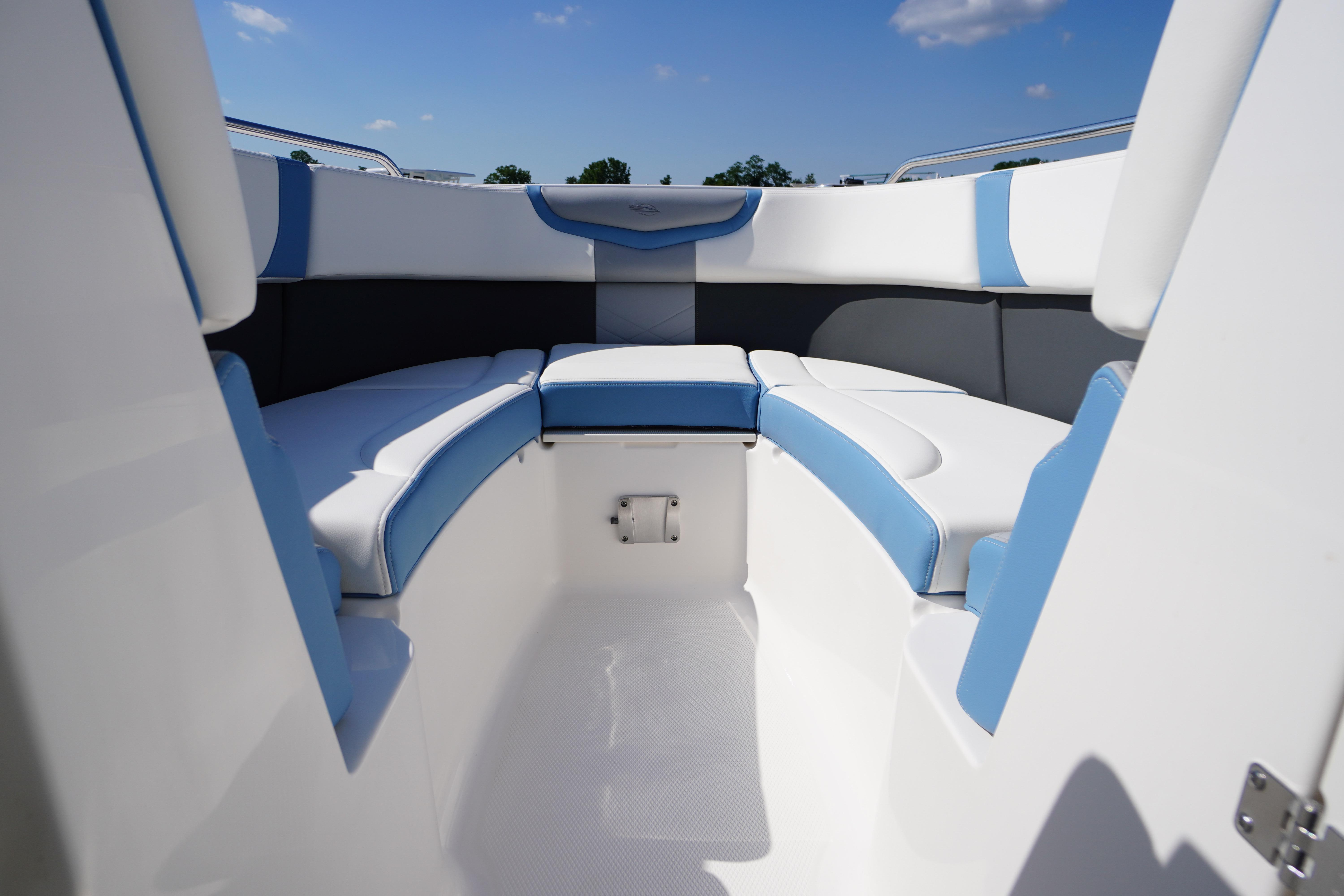 2026 Chaparral 270 OSX boat interior with blue and white seating under a clear sky.