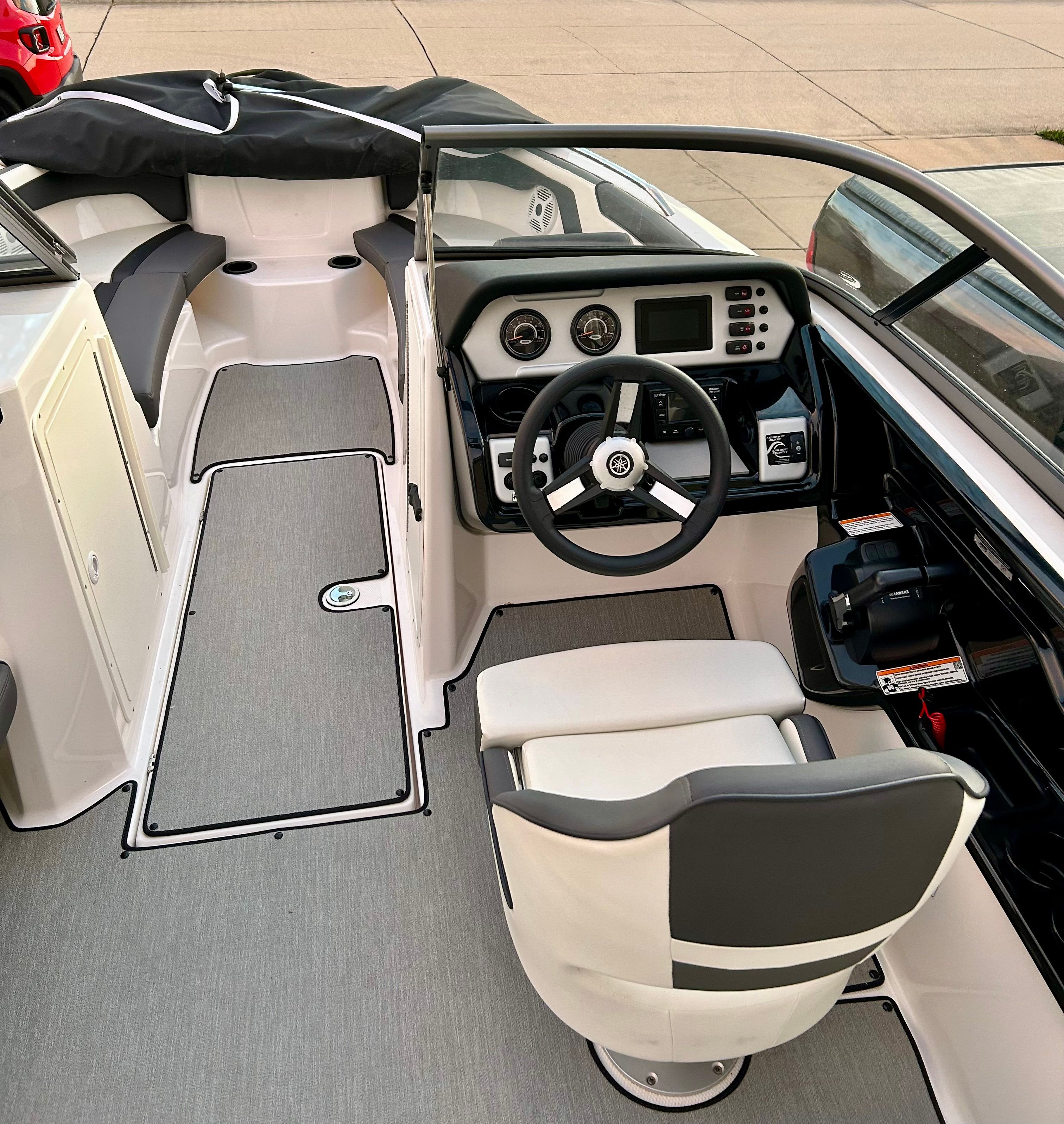 The image shows the cockpit of a 2022 Yamaha AR210 boat with modern instruments.