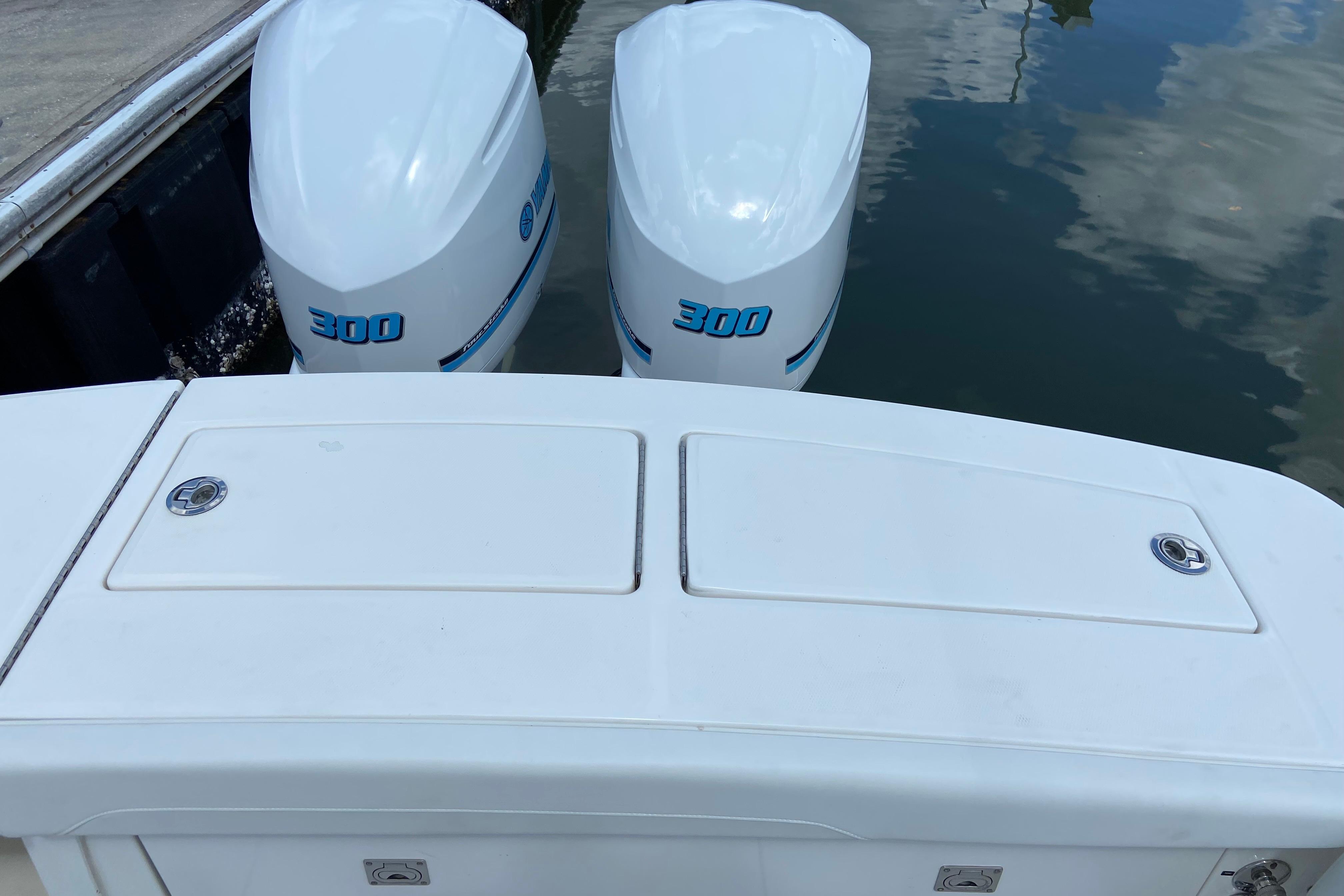 2021 Regulator 28 boat with twin 300 horsepower engines docked on calm water.