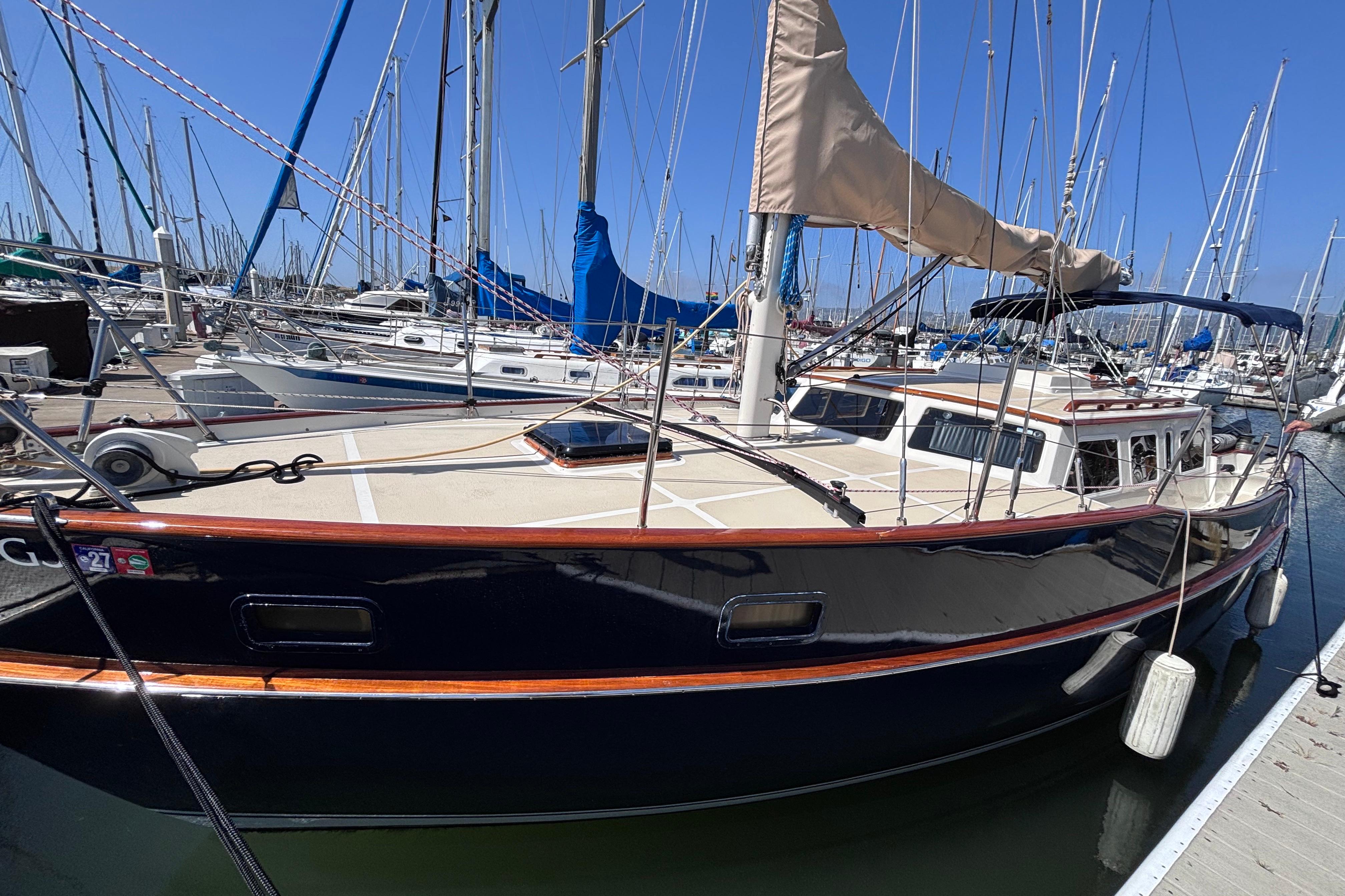 1978 Swift 33 sailboat docked in a marina, surrounded by other boats.