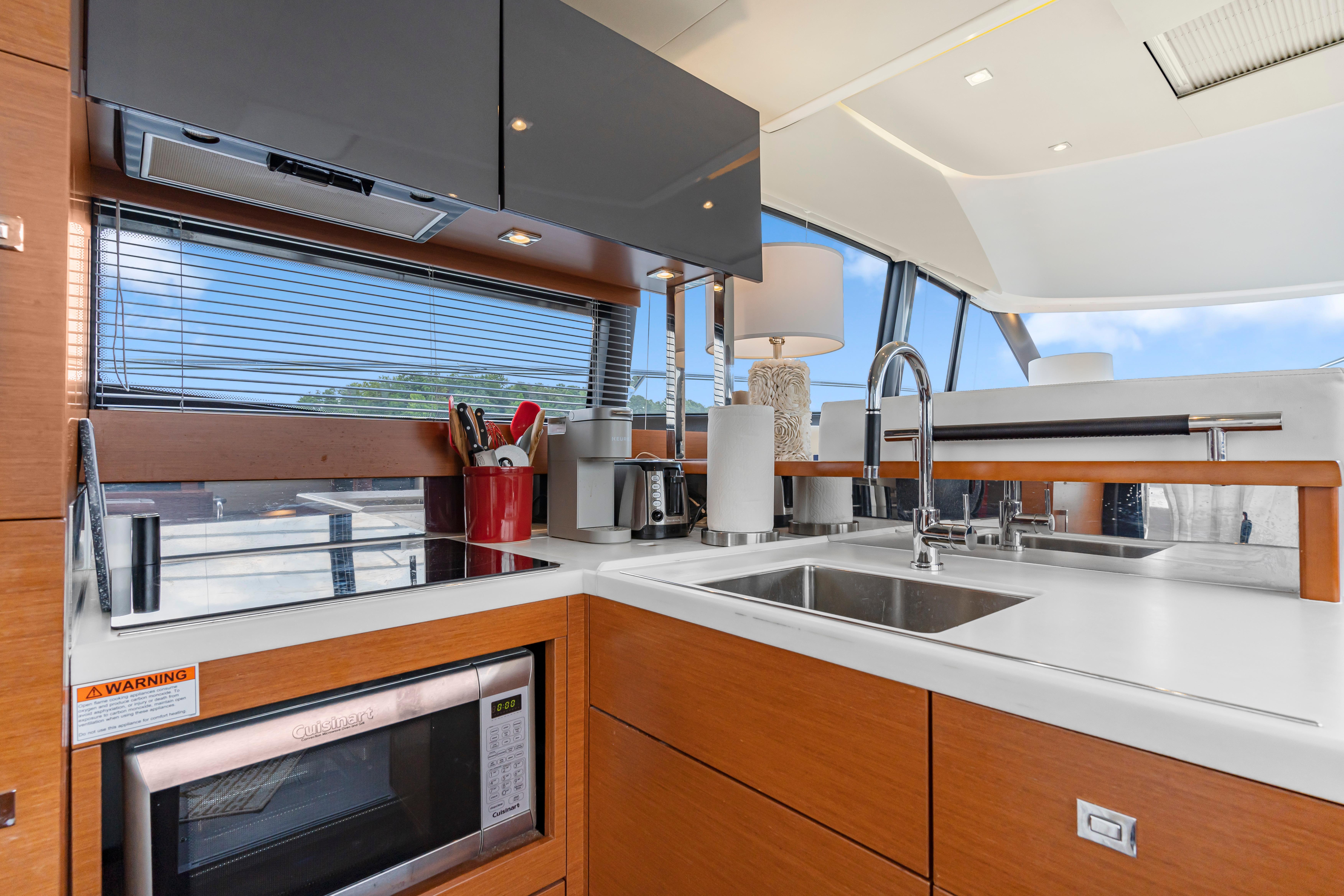 Modern kitchen interior on a 2017 Prestige 500 yacht, featuring sleek cabinetry and appliances.