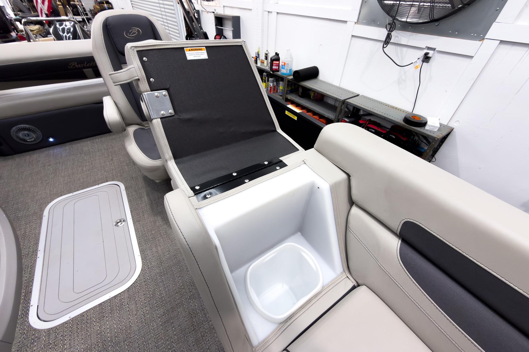 2025 Barletta Cabrio 24UC boat interior with open storage compartment and seating.