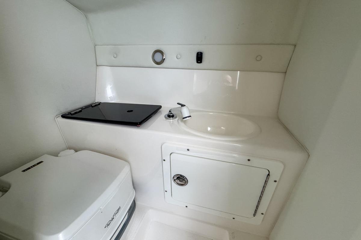 2022 Velocity 290sc boat interior with sink and storage compartment.