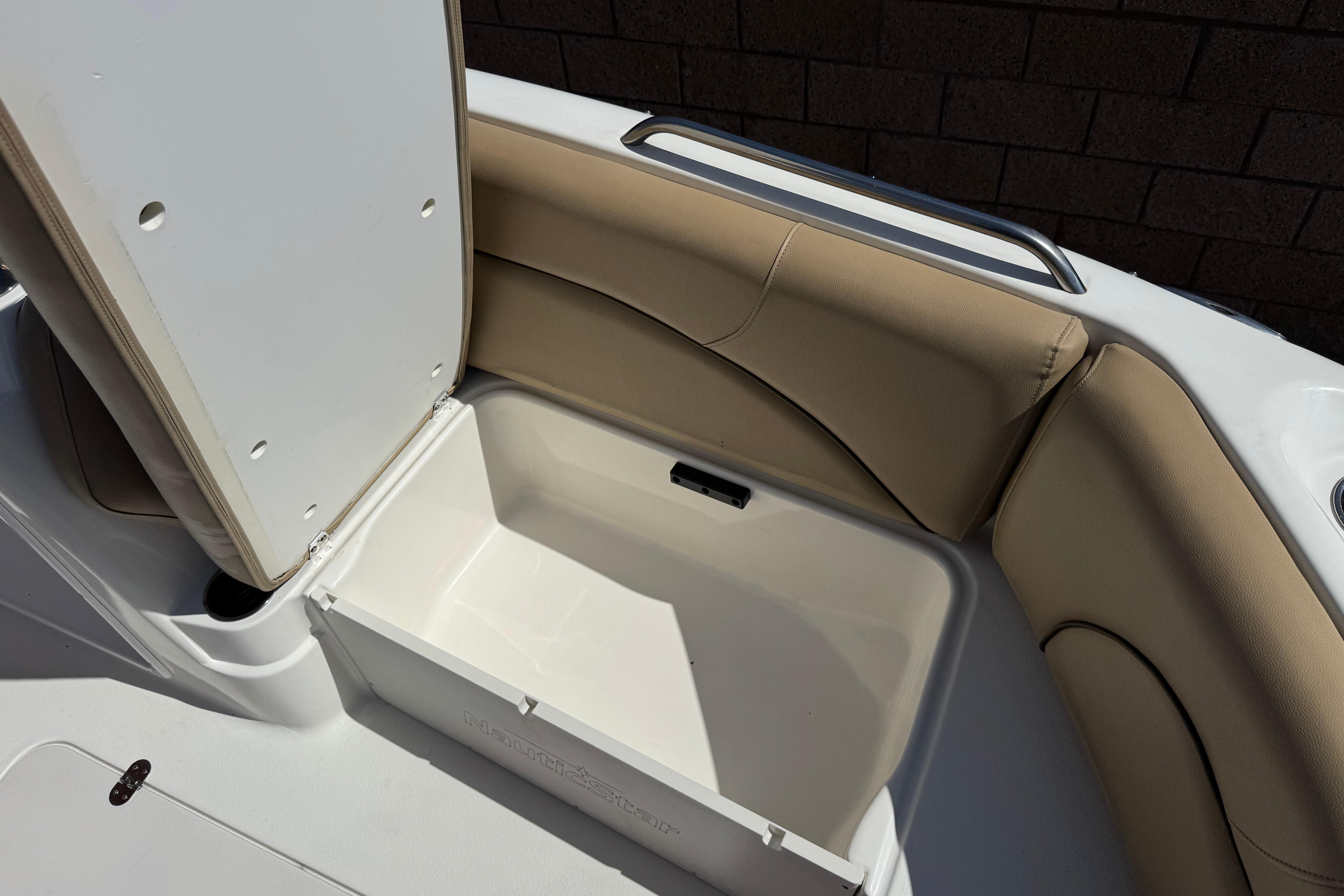 Open storage compartment on 2020 NauticStar 203 SC boat with beige seating.