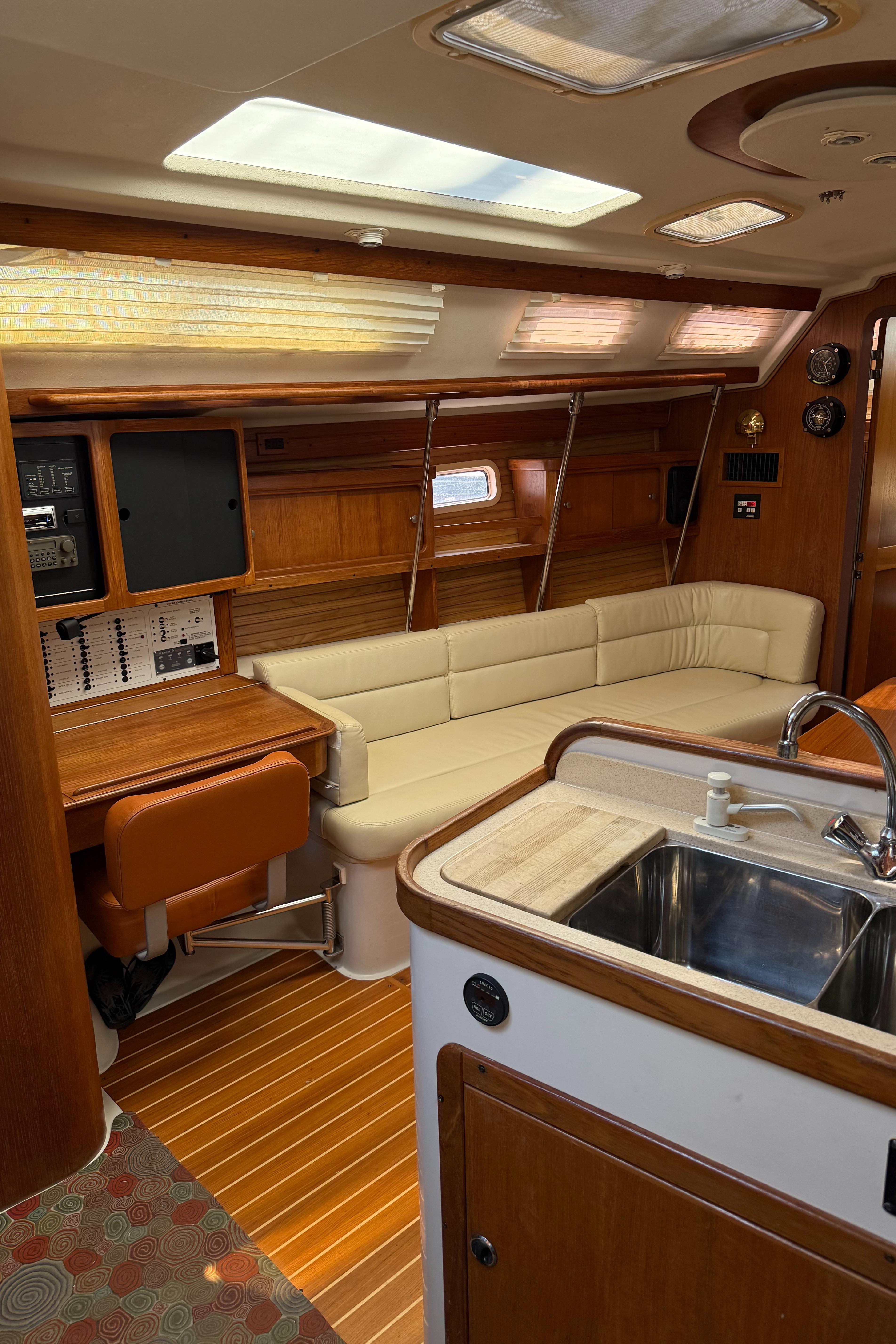 Interior of a 1998 Catalina 400 yacht with wooden finishes and a cozy seating area.