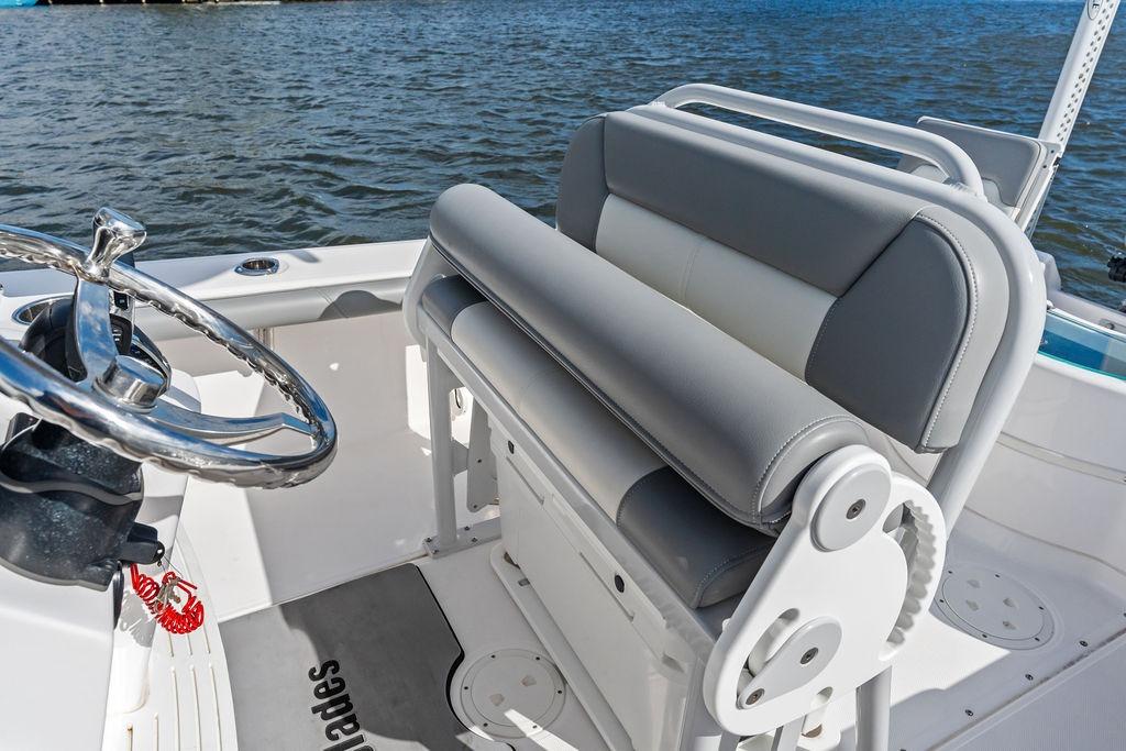 2023 Everglades 243 Center Console boat interior with steering wheel and seating, on water.