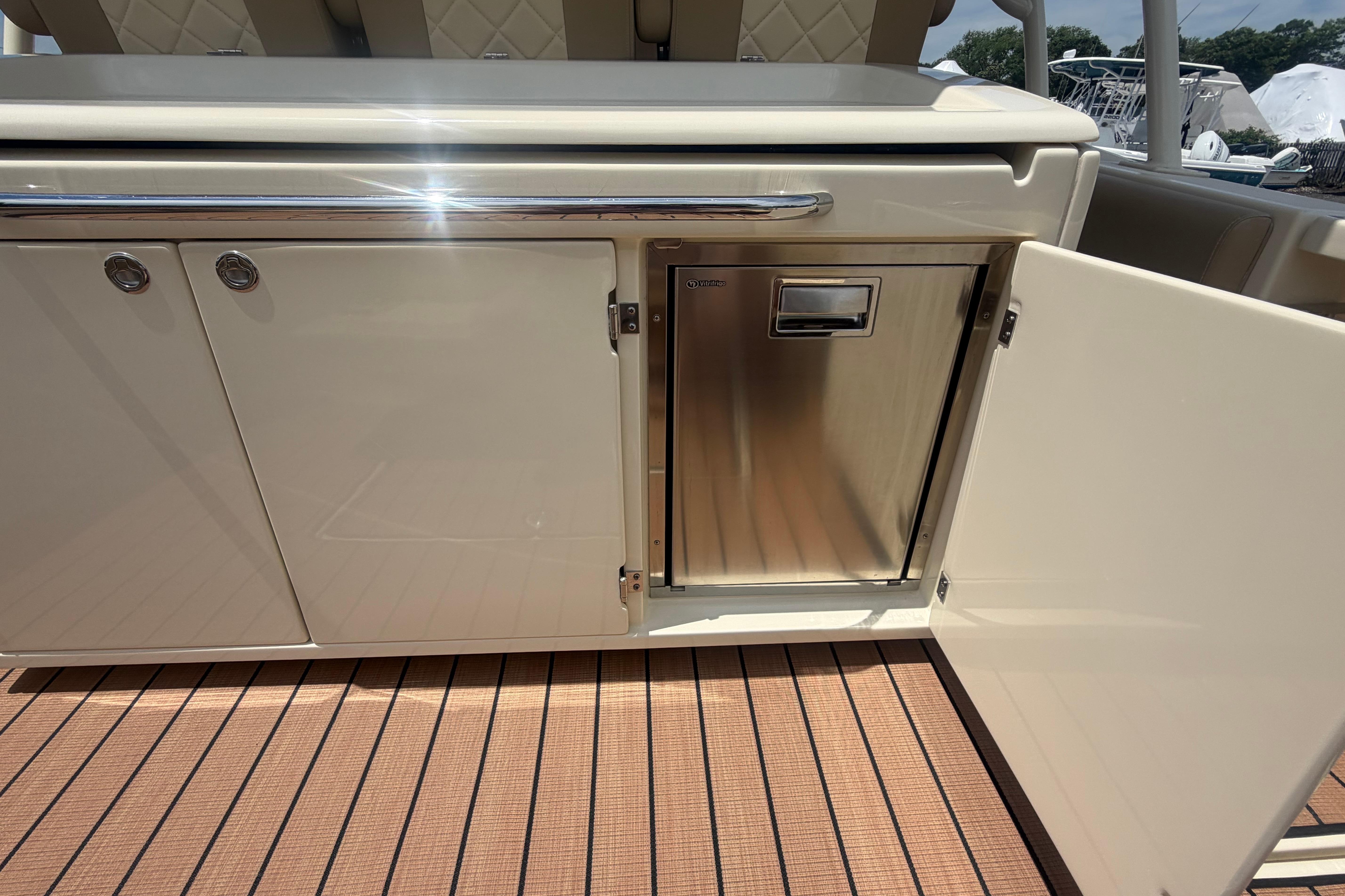 2017 Chris-Craft Catalina 34 boat interior with open storage compartment and stainless steel appliance.