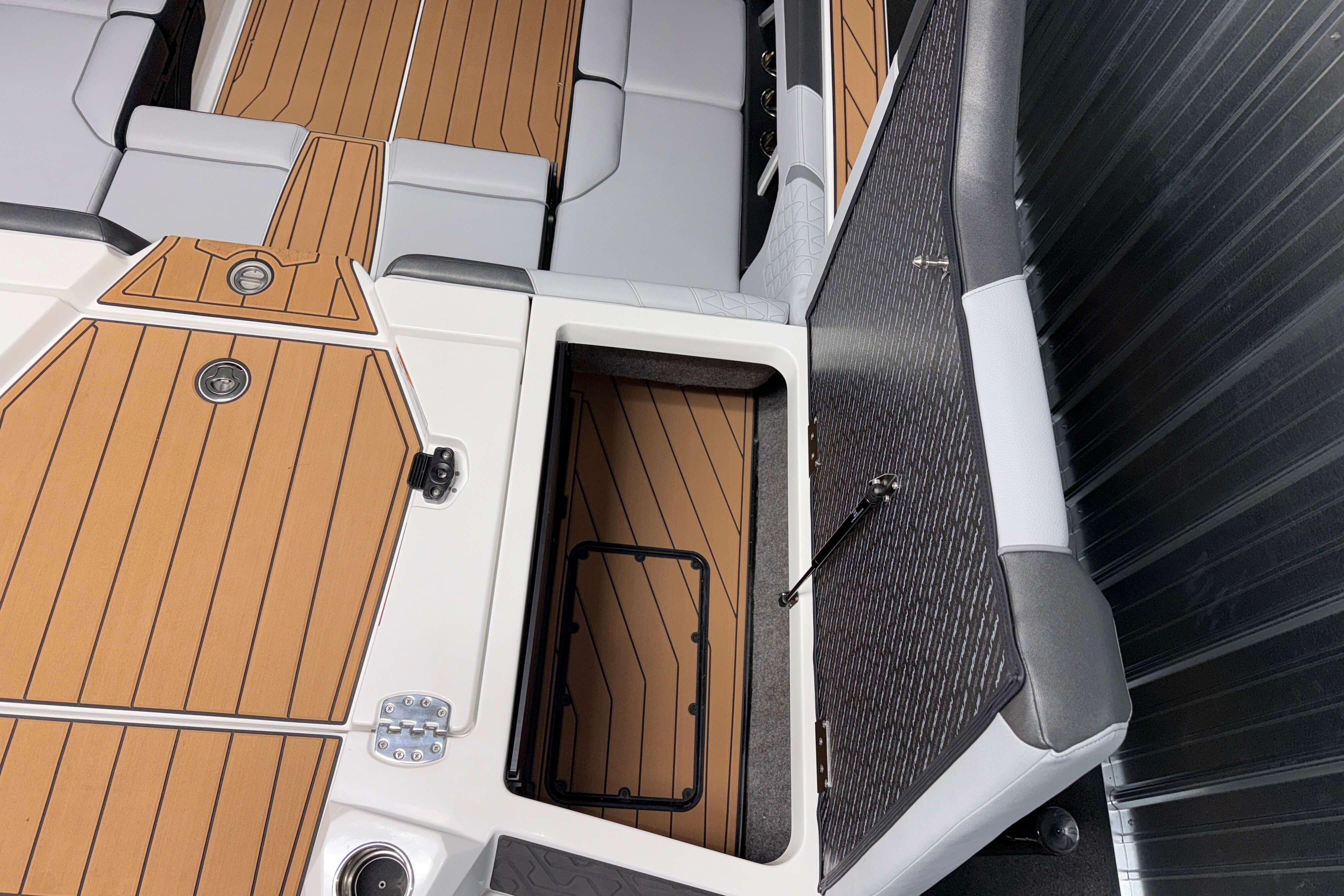 2026 Nautique Super Air Nautique GS22 interior with open storage compartment and cushioned seating.