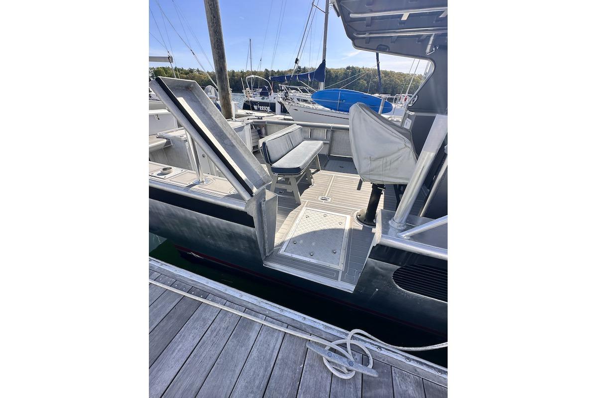 2009 Hunt 35 boat docked, featuring open deck and covered seating area.