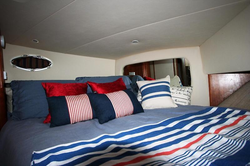 Cozy bedroom in 1999 Silverton 392 Motor Yacht with nautical-themed bedding.