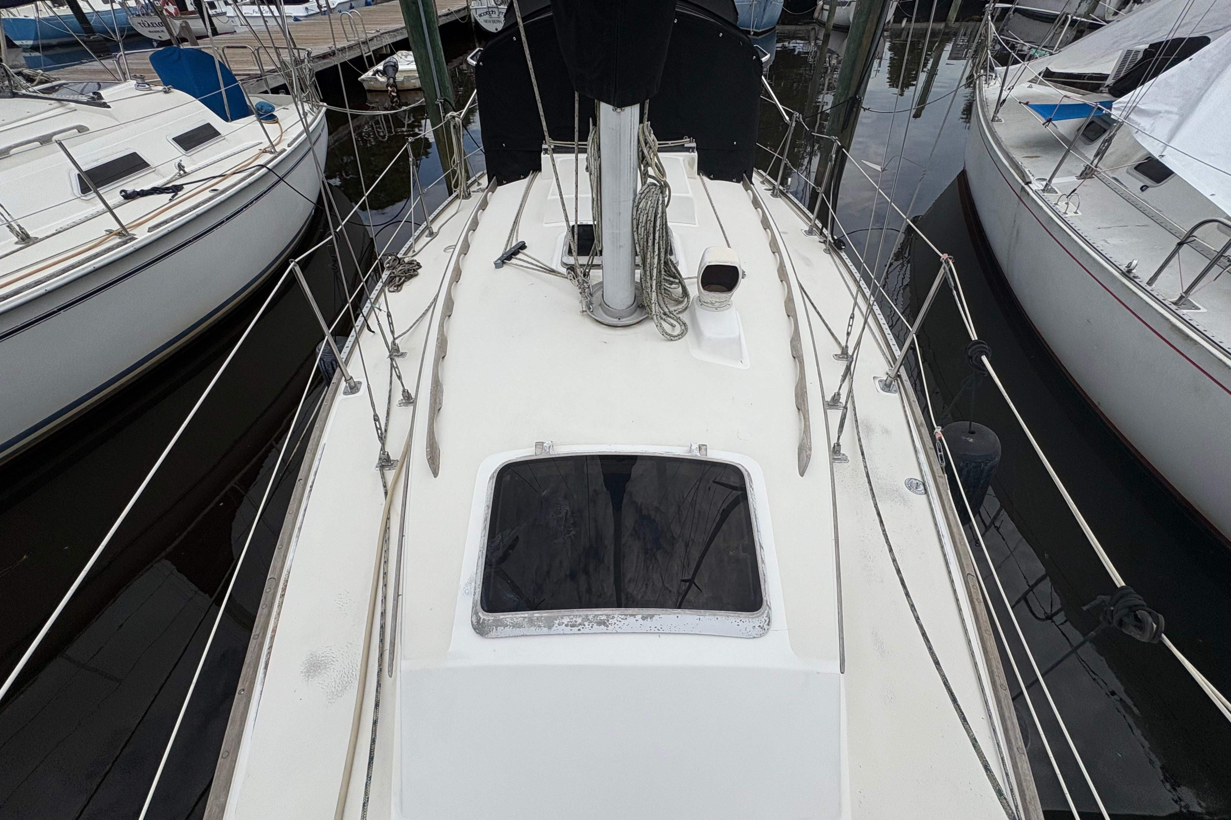 1981 Sabre 31 sailboat deck view, docked among other boats.