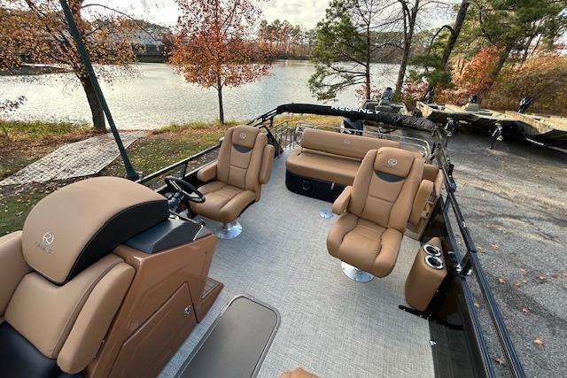 2025 Regency 230 LE3 Sport pontoon boat with luxurious seating by a scenic lake.